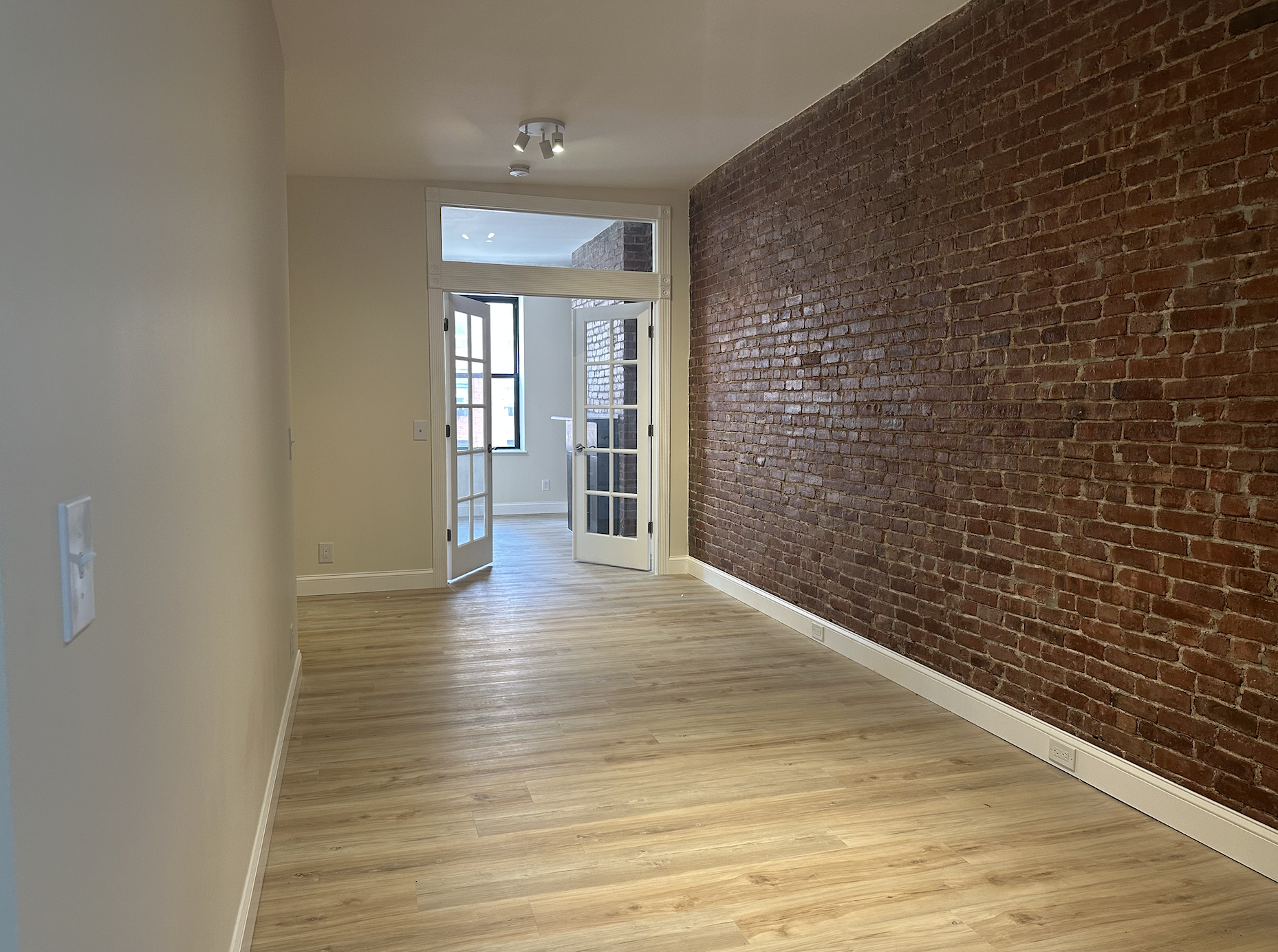 458 West 57th Street, Unit 4FE Manhattan, NY 10019 - Photo 4 of 13 a view of interior space with wooden floor and brick wall