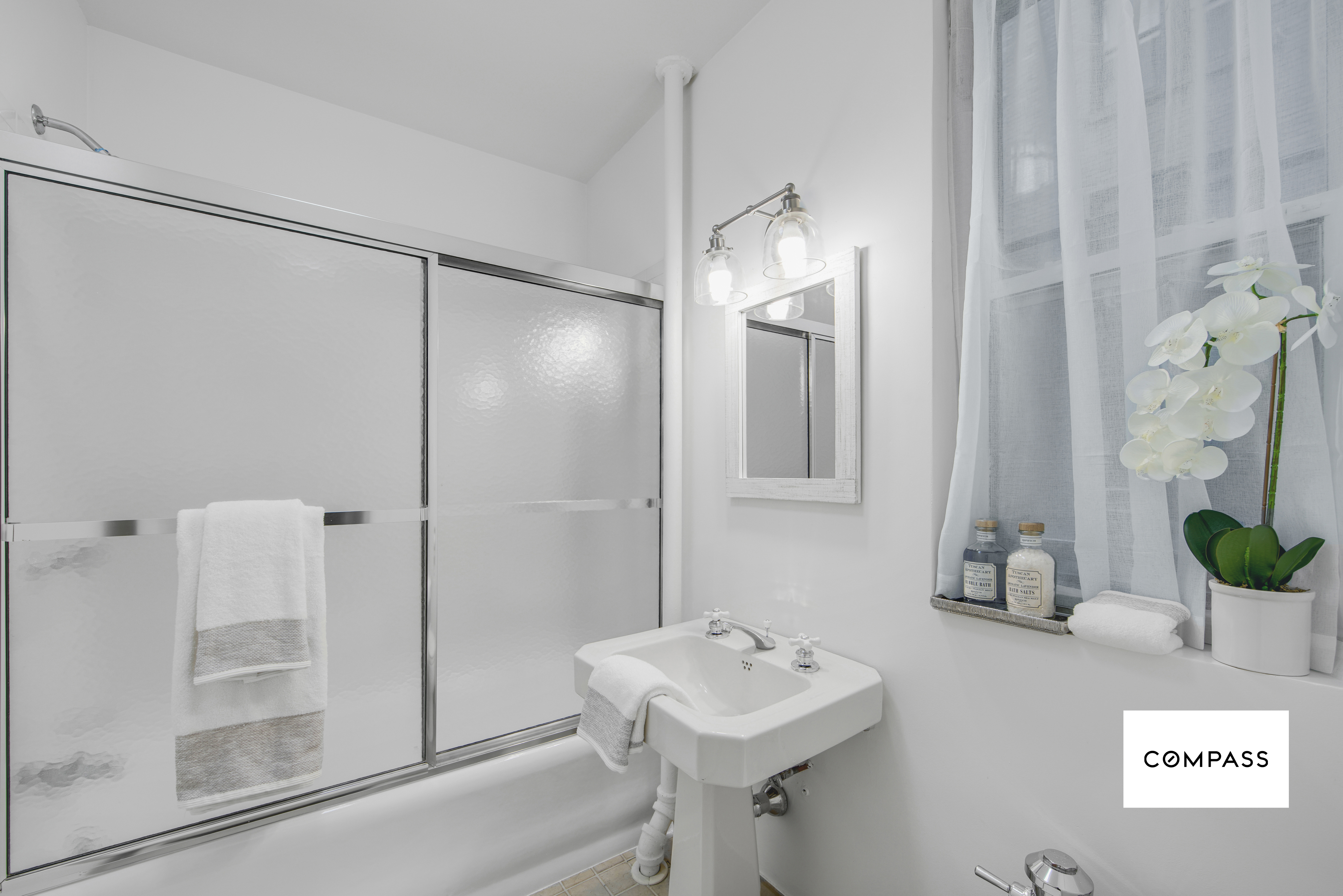 124 East 84th Street, Unit 1D Manhattan, NY 10028 - Photo 11 of 14 a bathroom with a sink a mirror and a shower