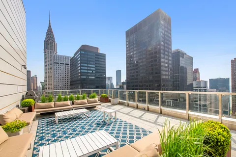 a view of roof deck with a barbeque and wooden stairs