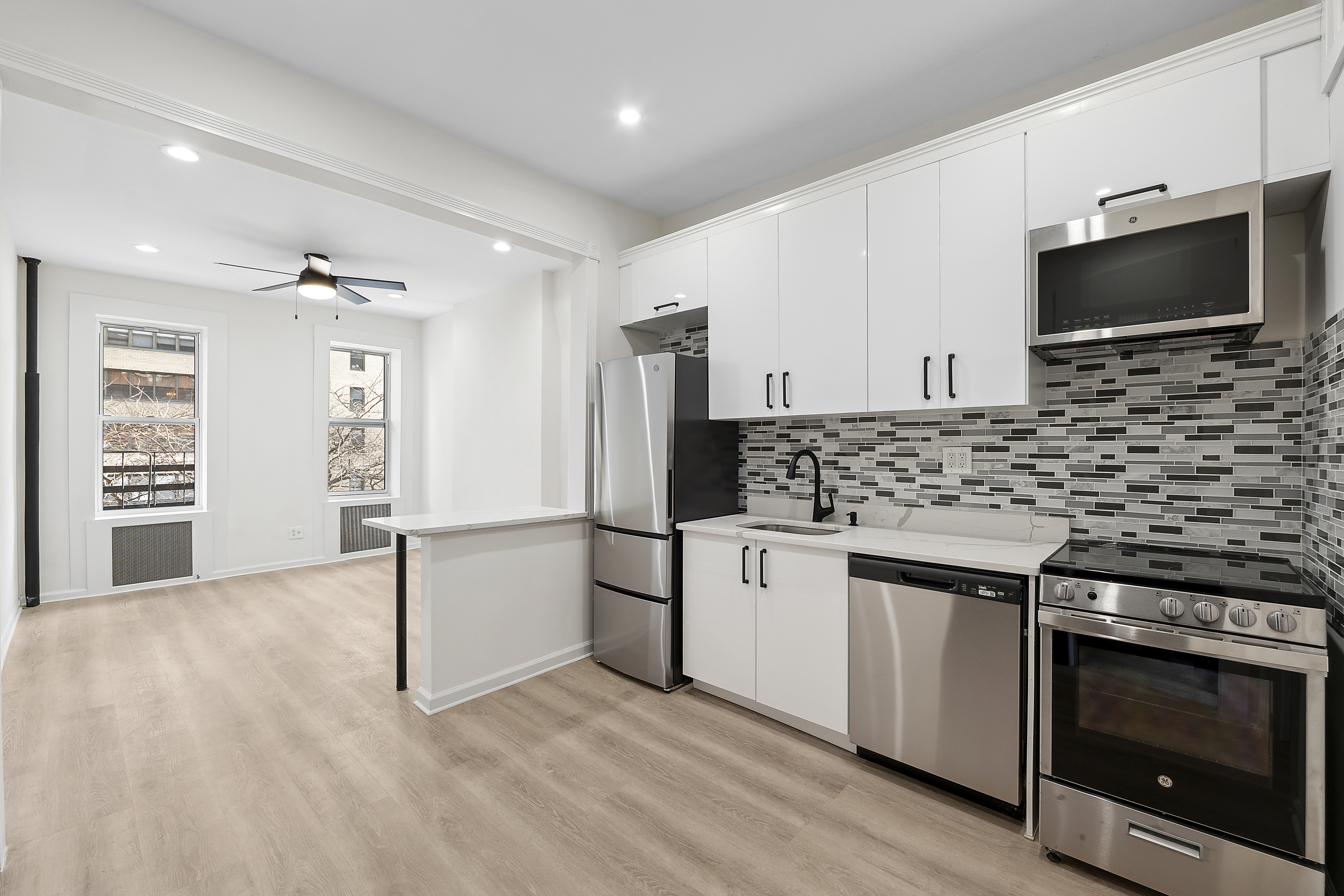 398 3rd Avenue, Unit 2D Manhattan, NY 10016 - Photo 3 of 10 a kitchen with granite countertop a stove and a microwave