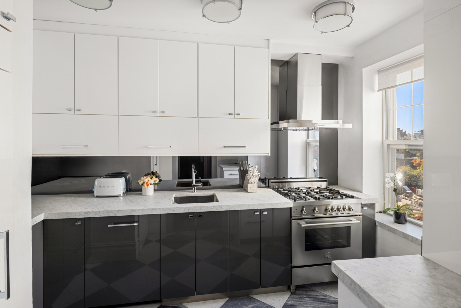 15 West 11th Street, Unit 9A Manhattan, NY 10011 - Photo 5 of 9 a kitchen with stainless steel appliances granite countertop a stove a sink and a refrigerator