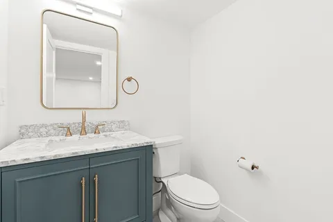 a bathroom with a toilet a sink and mirror