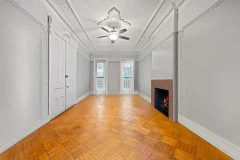 a view of an empty room with a fireplace and a window
