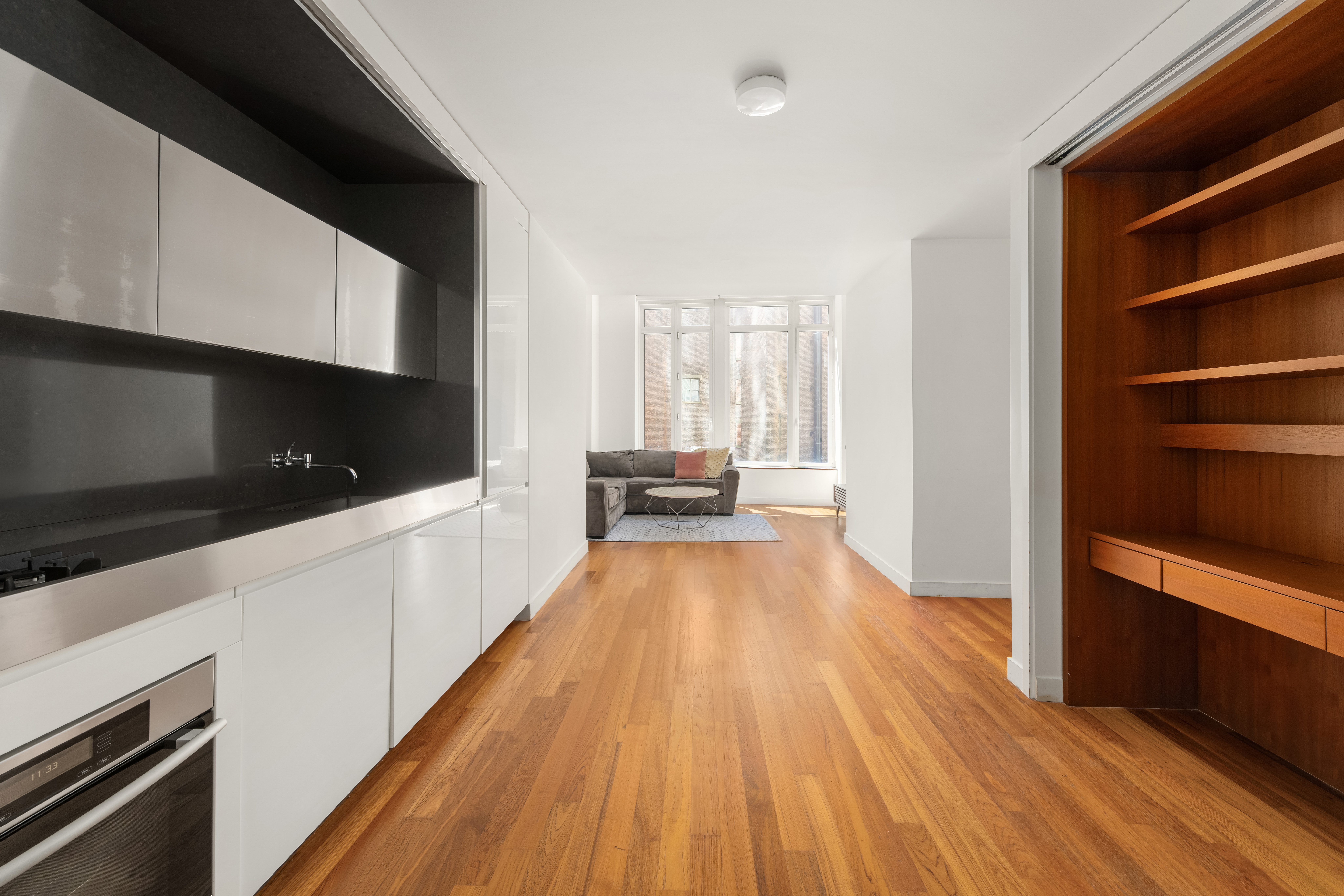 15 William Street, Unit 7B Manhattan, NY 10005 - Photo 2 of 9 a view of a hallway with wooden floor and cabinets