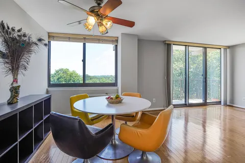a dining room with furniture a chandelier and wooden floor