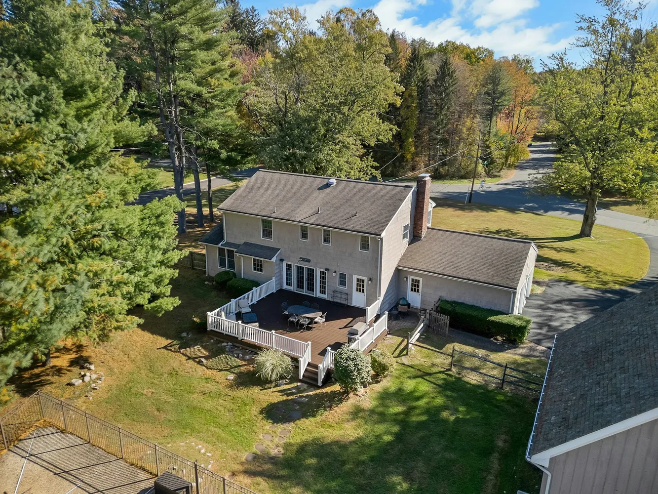a view of house with a big yard potted plants and large tree