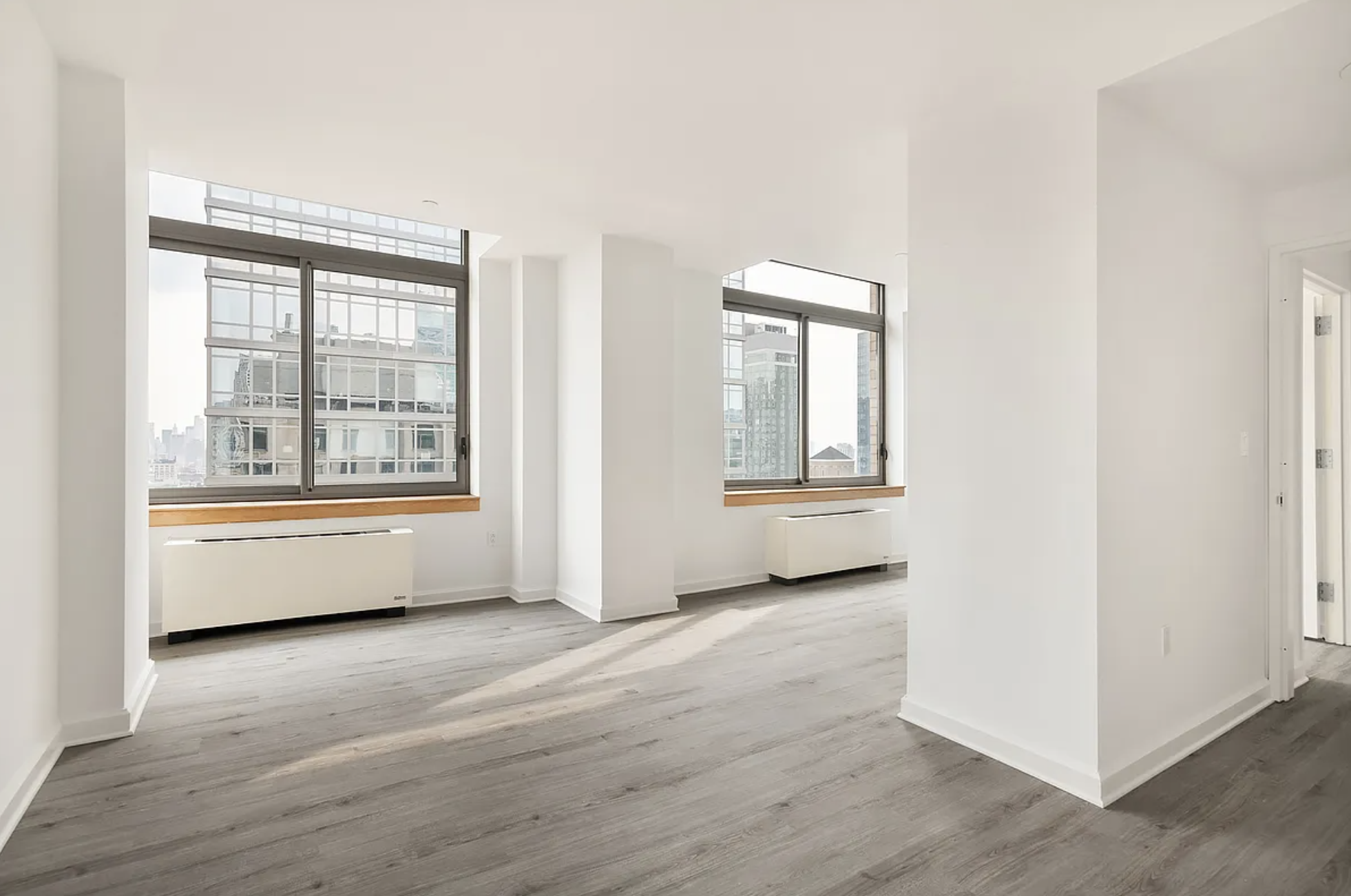 35 West 33rd Street, Unit 32C Manhattan, NY 10001 - Photo 1 of 21 an empty room with wooden floor and windows