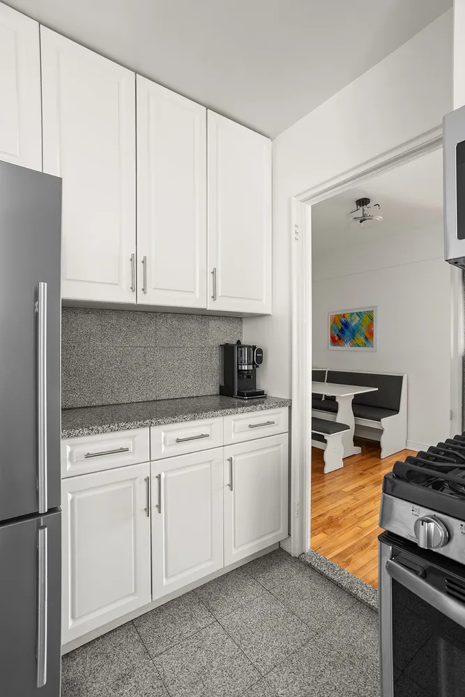 a kitchen with white cabinets and appliances
