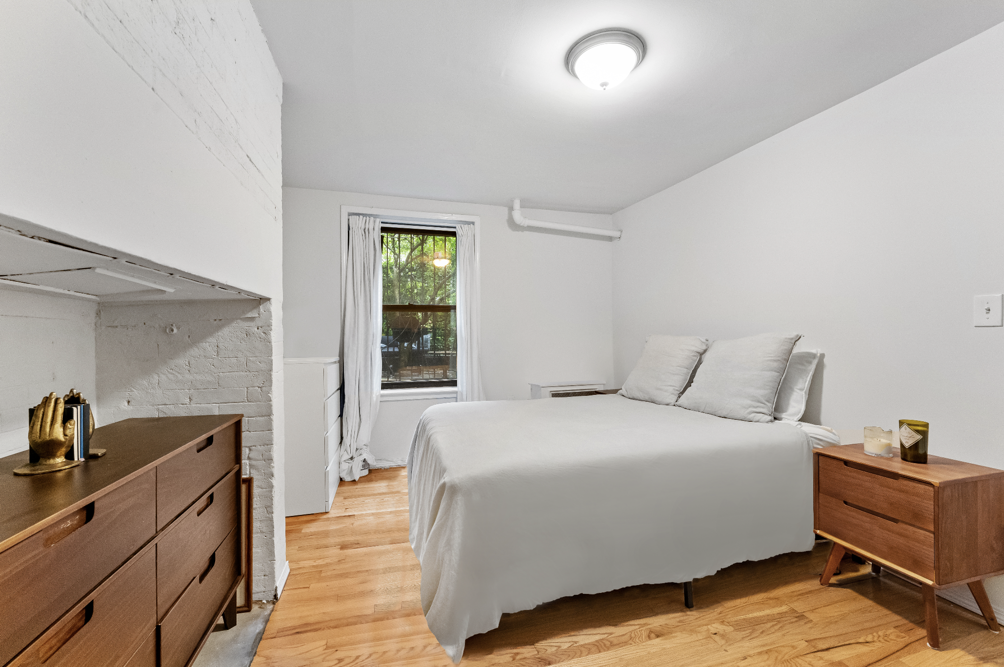 355 West 20th Street, Unit 1 Manhattan, NY 10011 - Photo 6 of 9 a spacious bedroom with a bed and a dresser