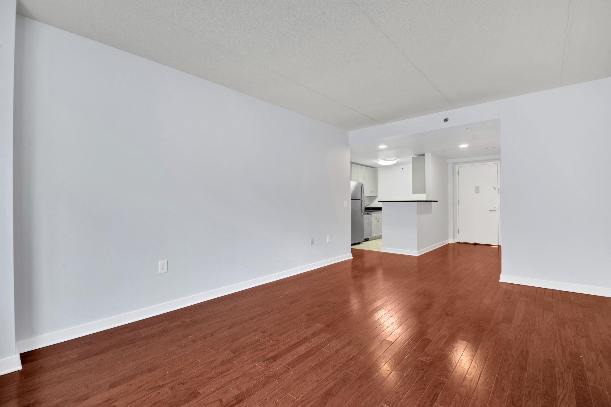 a view of kitchen with refrigerator and wooden floor