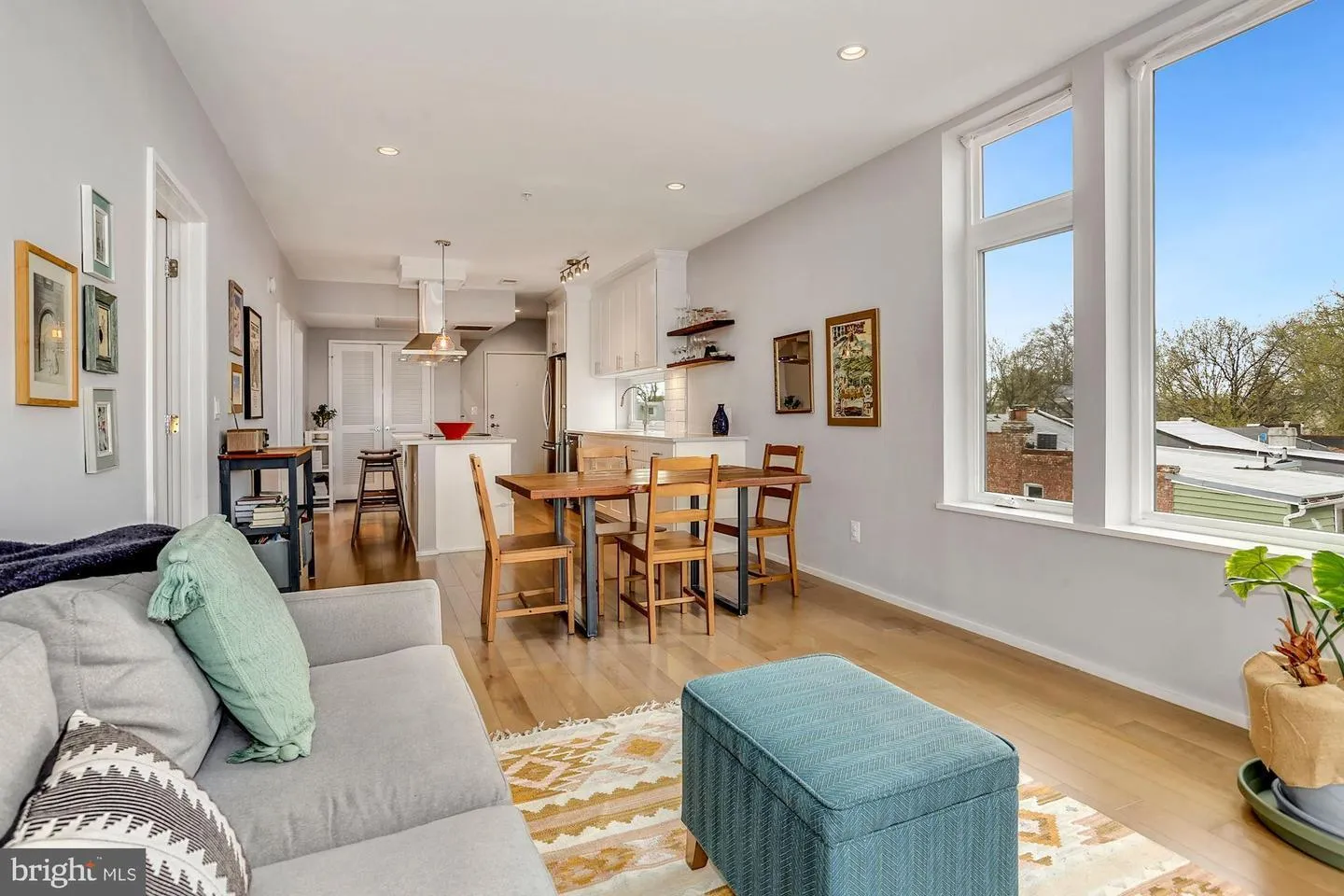 a living room with furniture wooden floor and kitchen view