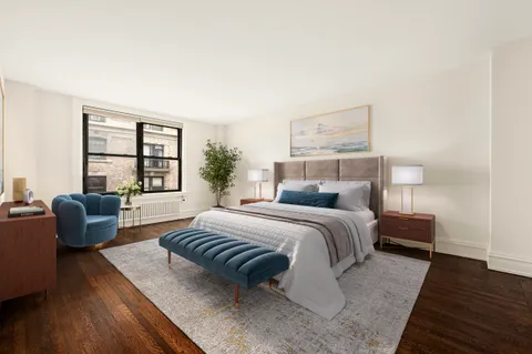 a bedroom with a bed and a couch with wooden floor