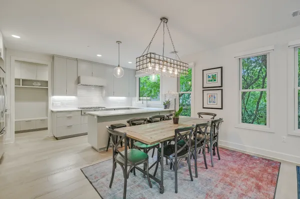 a kitchen with stainless steel appliances a stove a table and chairs in it