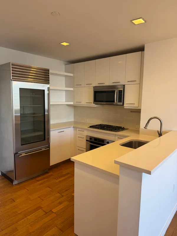 a kitchen with stainless steel appliances a refrigerator and a stove top oven