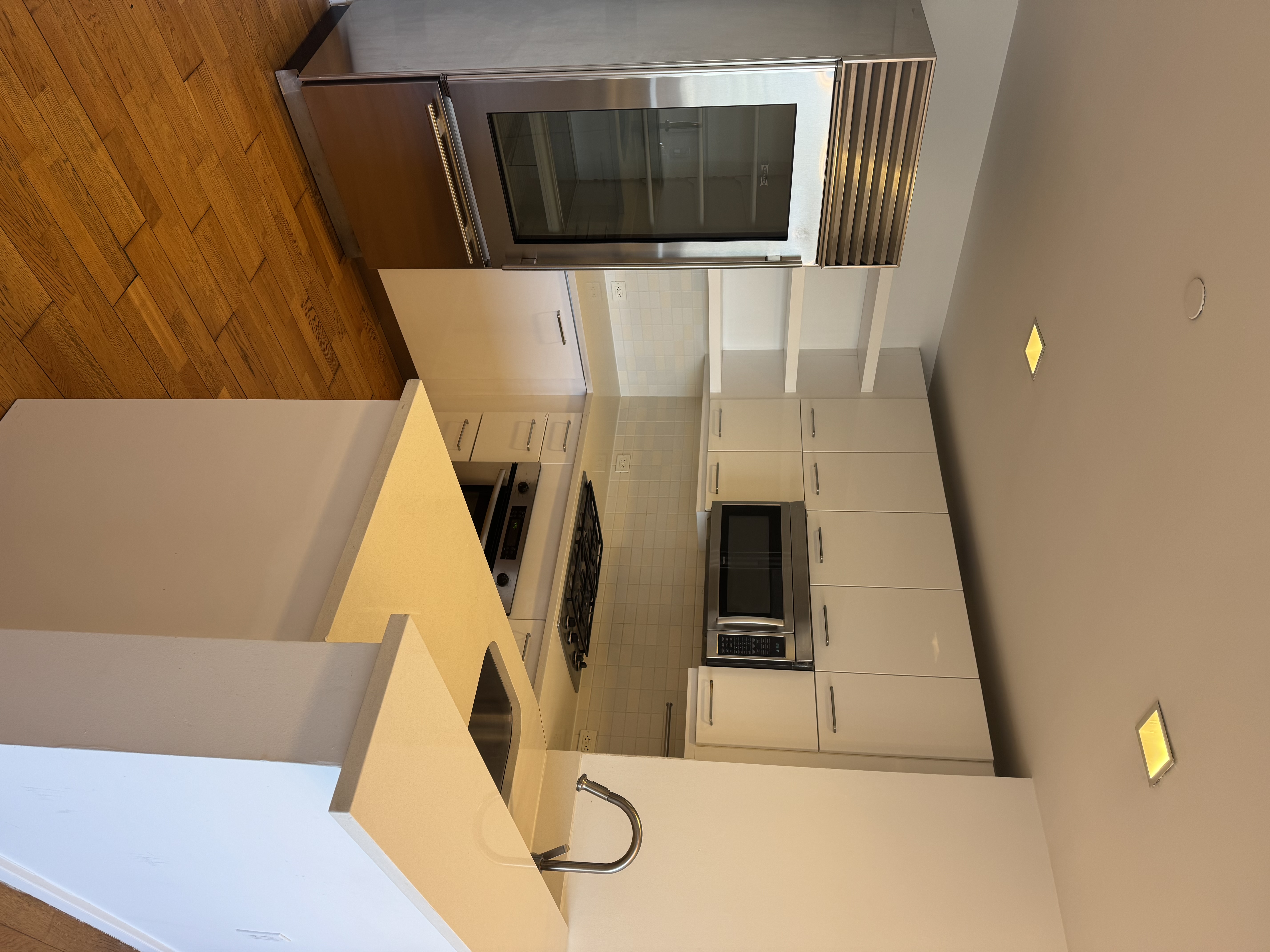 635 West 42nd Street, Unit 10C Manhattan, NY 10036 - Photo 3 of 10 a kitchen with stainless steel appliances a refrigerator and a stove top oven