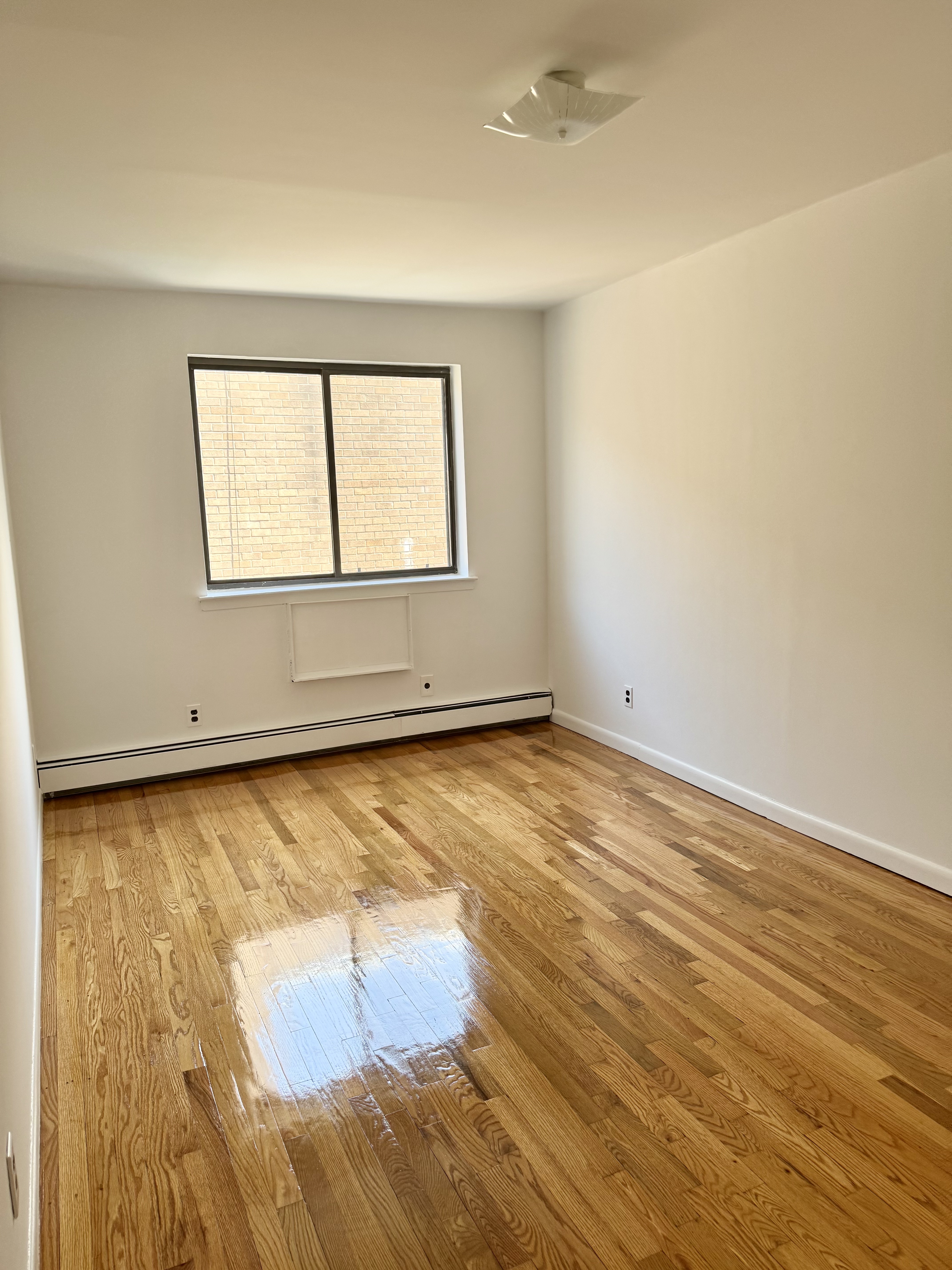 59-15 39th Avenue, Unit 2 Queens, NY 11377 - Photo 7 of 13 an empty room with a window