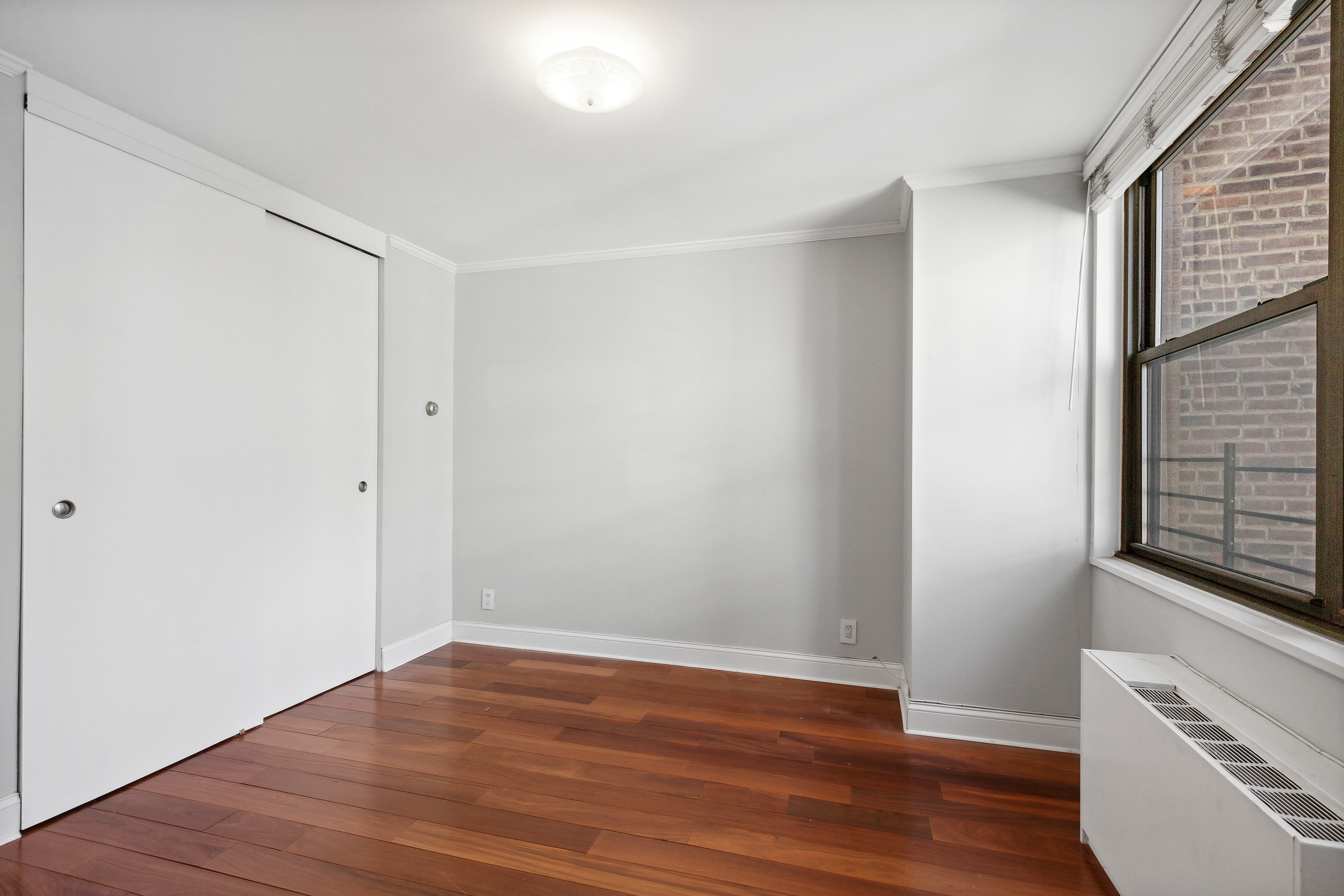 444 East 86th Street, Unit 11B Manhattan, NY 10028 - Photo 12 of 18 a view of an empty room with wooden floor and a window