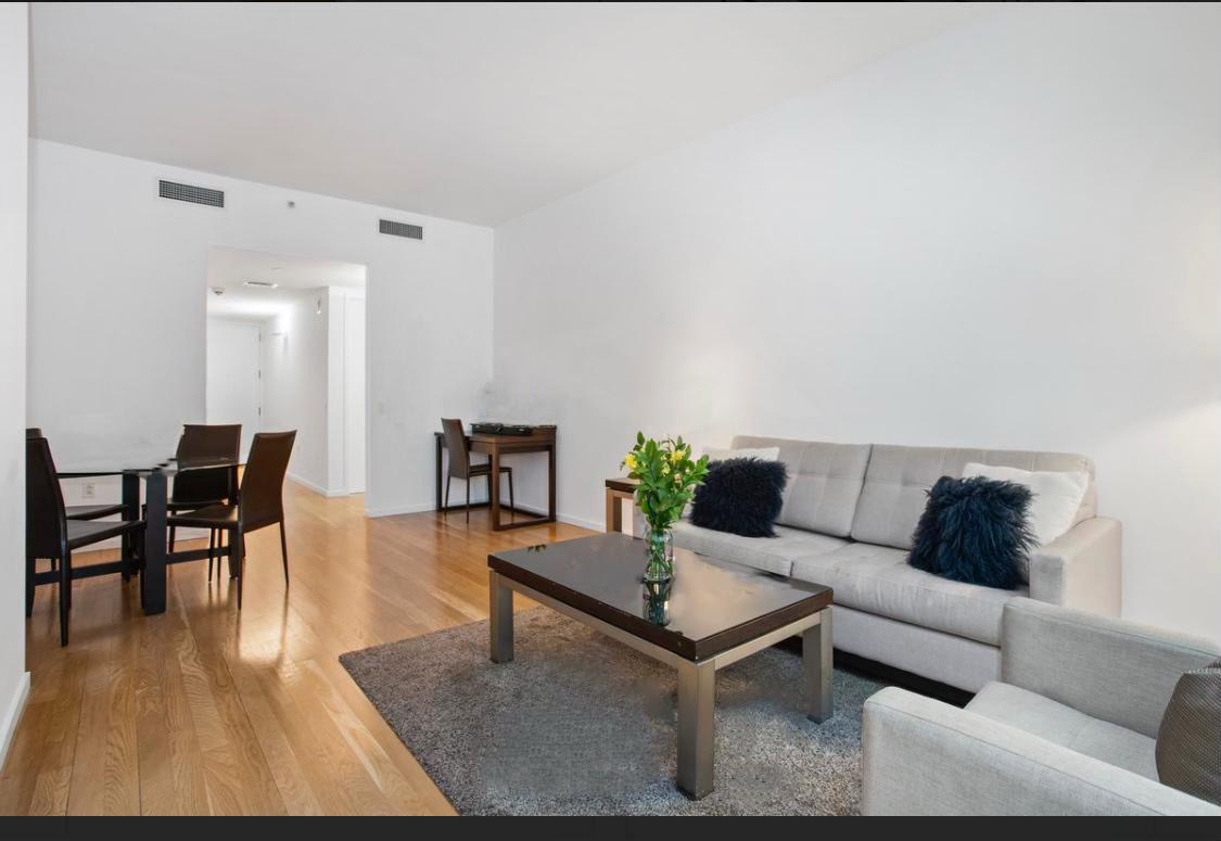 18 West 48th Street, Unit 3B Manhattan, NY 10036 - Photo 6 of 8 a living room with furniture and wooden floor