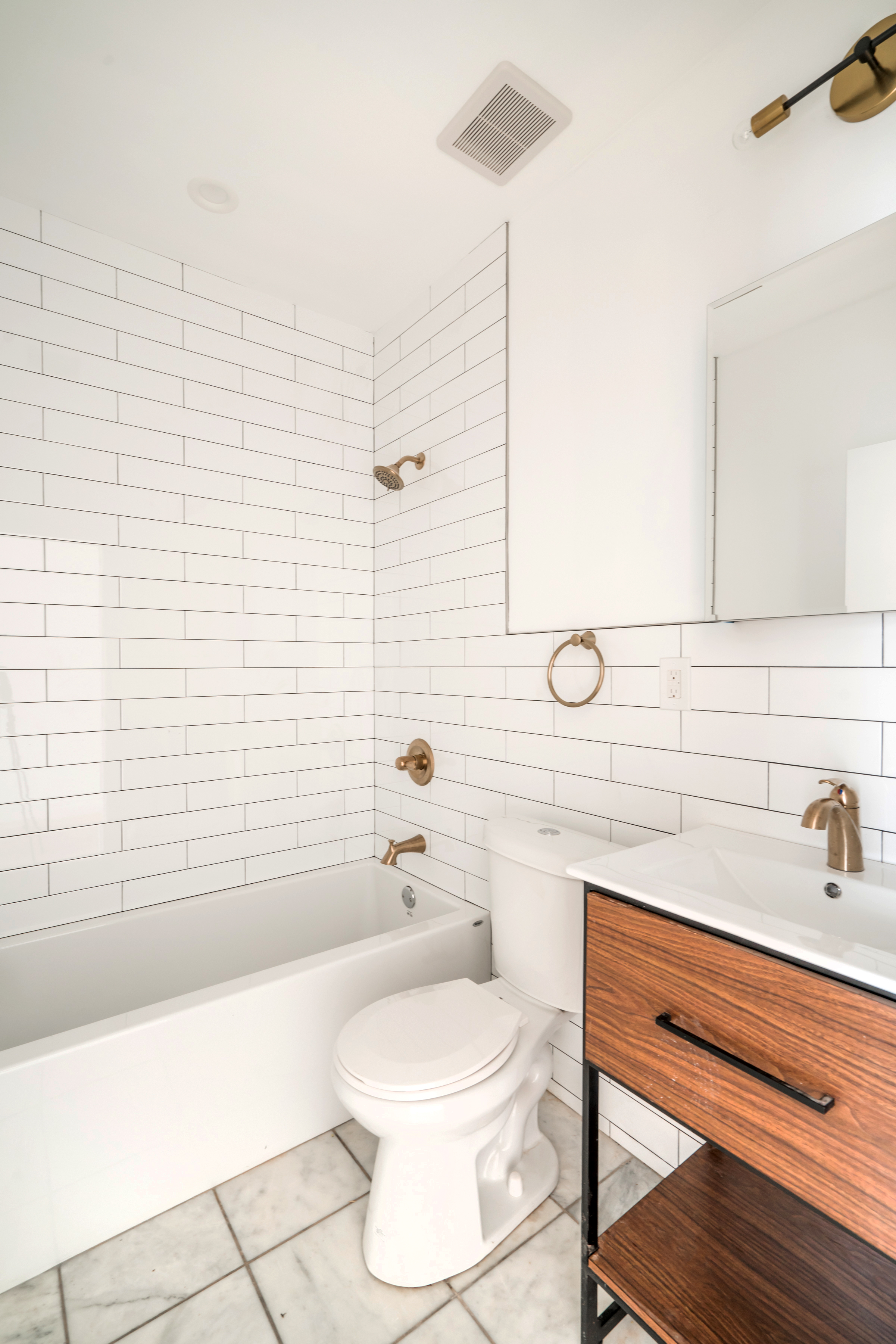 885 Lafayette Avenue, Unit 3 Brooklyn, NY 11221 - Photo 6 of 8 a bathroom with a toilet a sink a mirror and bathtub
