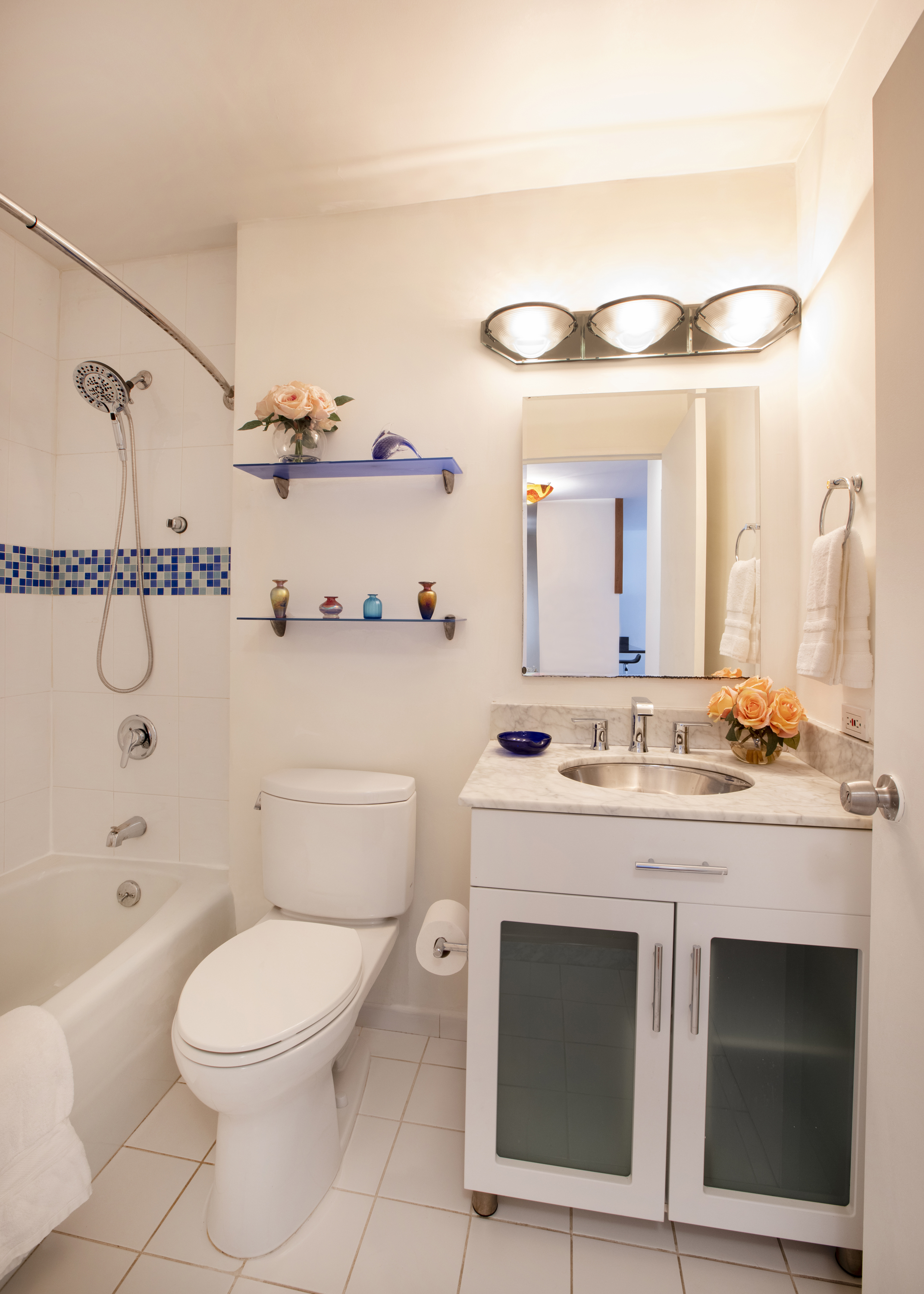 300 East 59th Street, Unit 803 Manhattan, NY 10022 - Photo 6 of 14 a bathroom with a granite countertop toilet sink and mirror