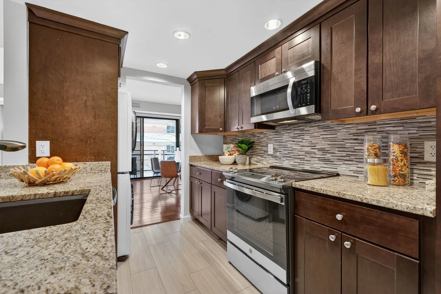 a kitchen with stainless steel appliances granite countertop a sink stove and microwave