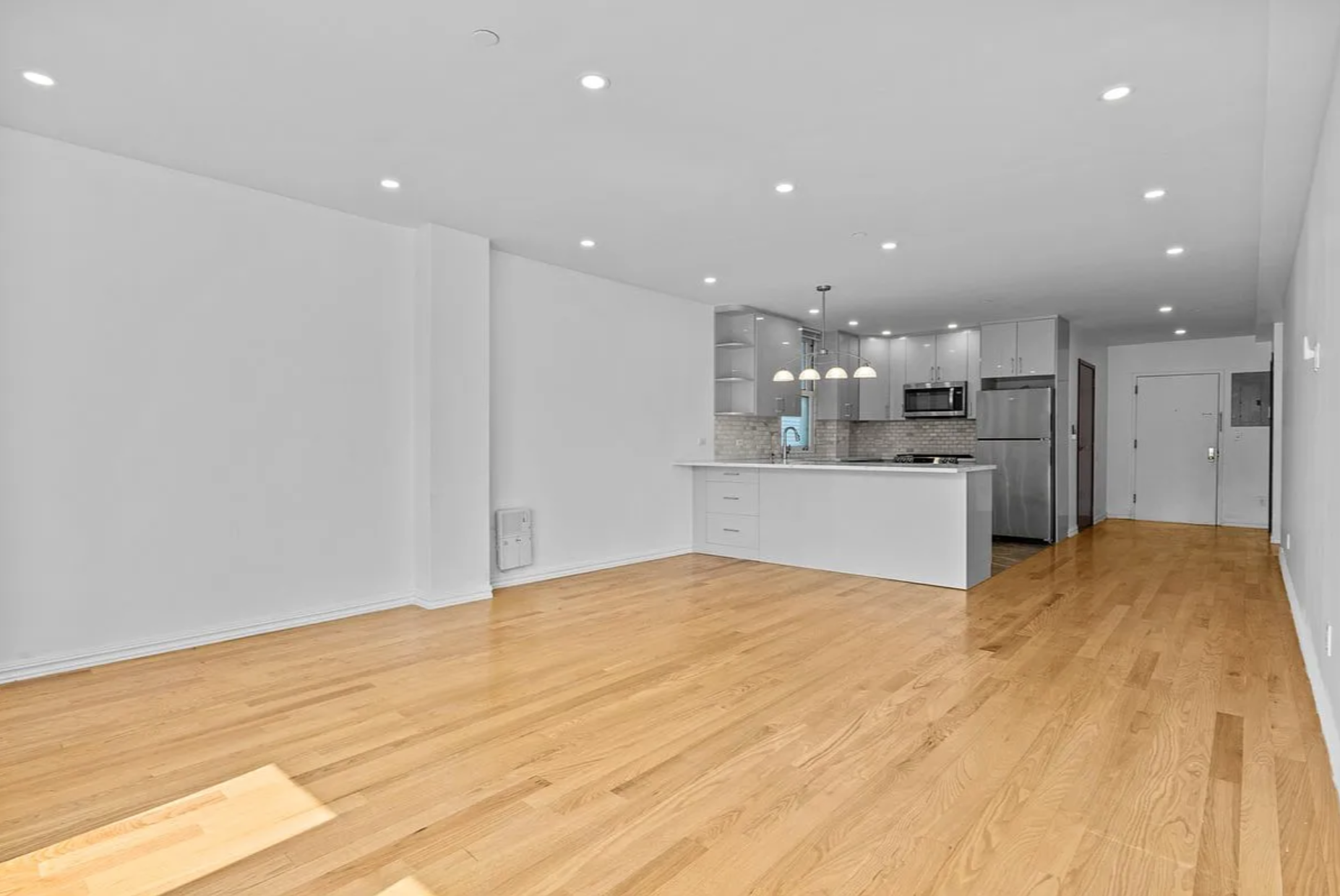 2882 West 15th Street, Unit 2B Brooklyn, NY 11224 - Photo 2 of 13 a view of kitchen with kitchen island a sink wooden floor and white cabinets