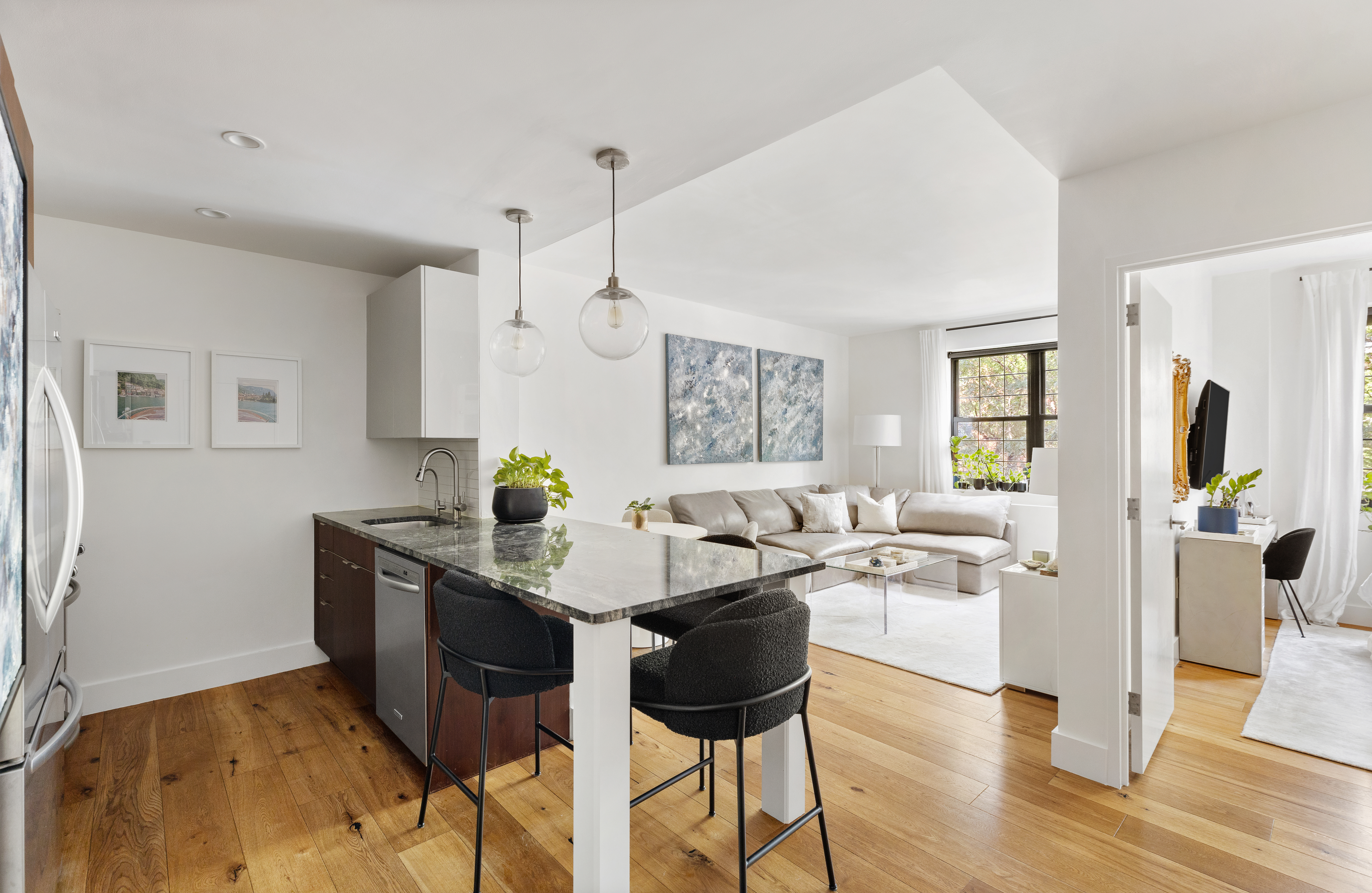 a living room with stainless steel appliances kitchen island granite countertop furniture and a wooden floor