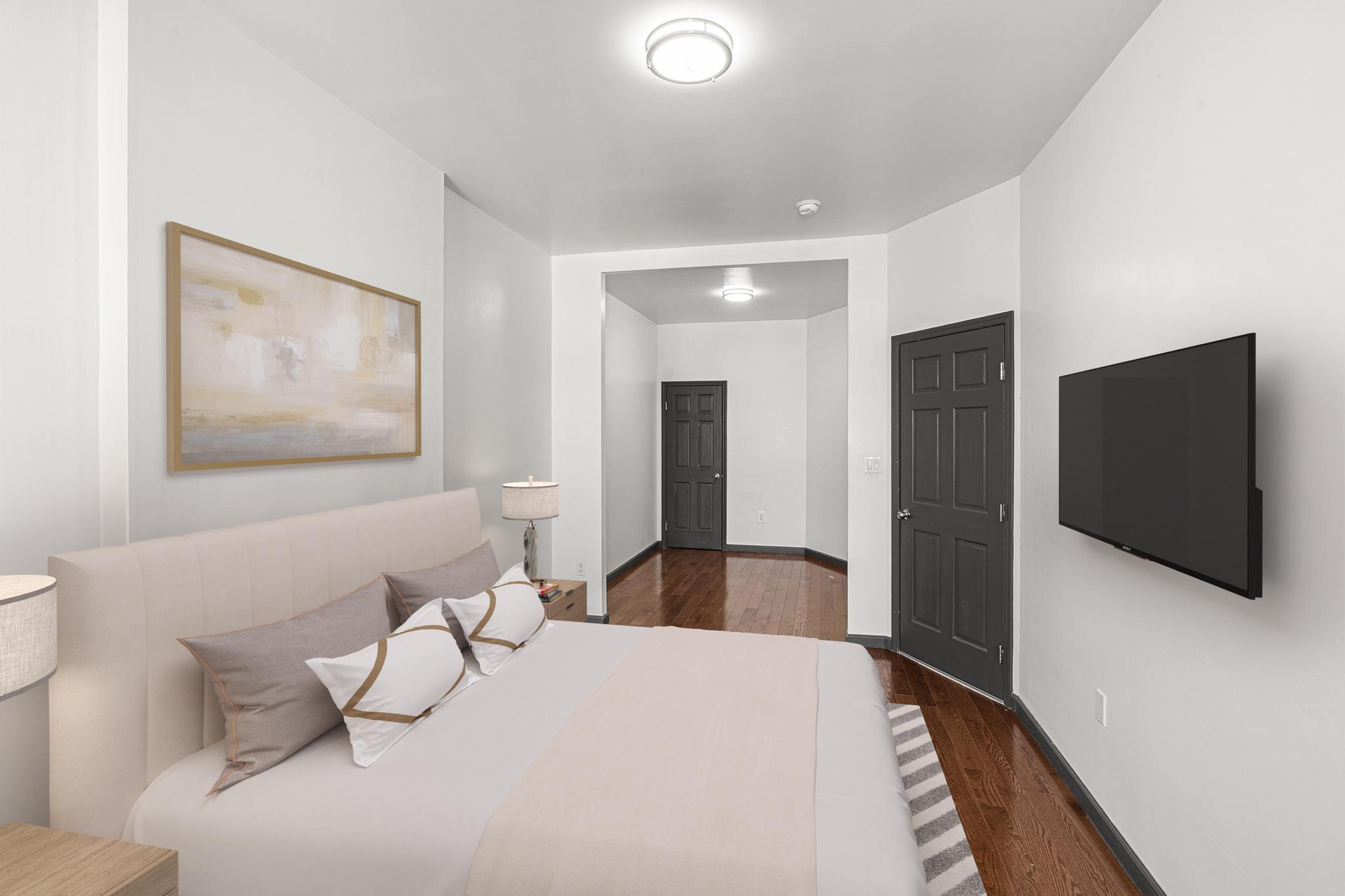 1389 Fulton Street, Unit 3 Brooklyn, NY 11216 - Photo 3 of 12 a bedroom with a bed and a flat screen tv