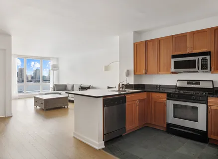 a kitchen with sink a microwave and cabinets