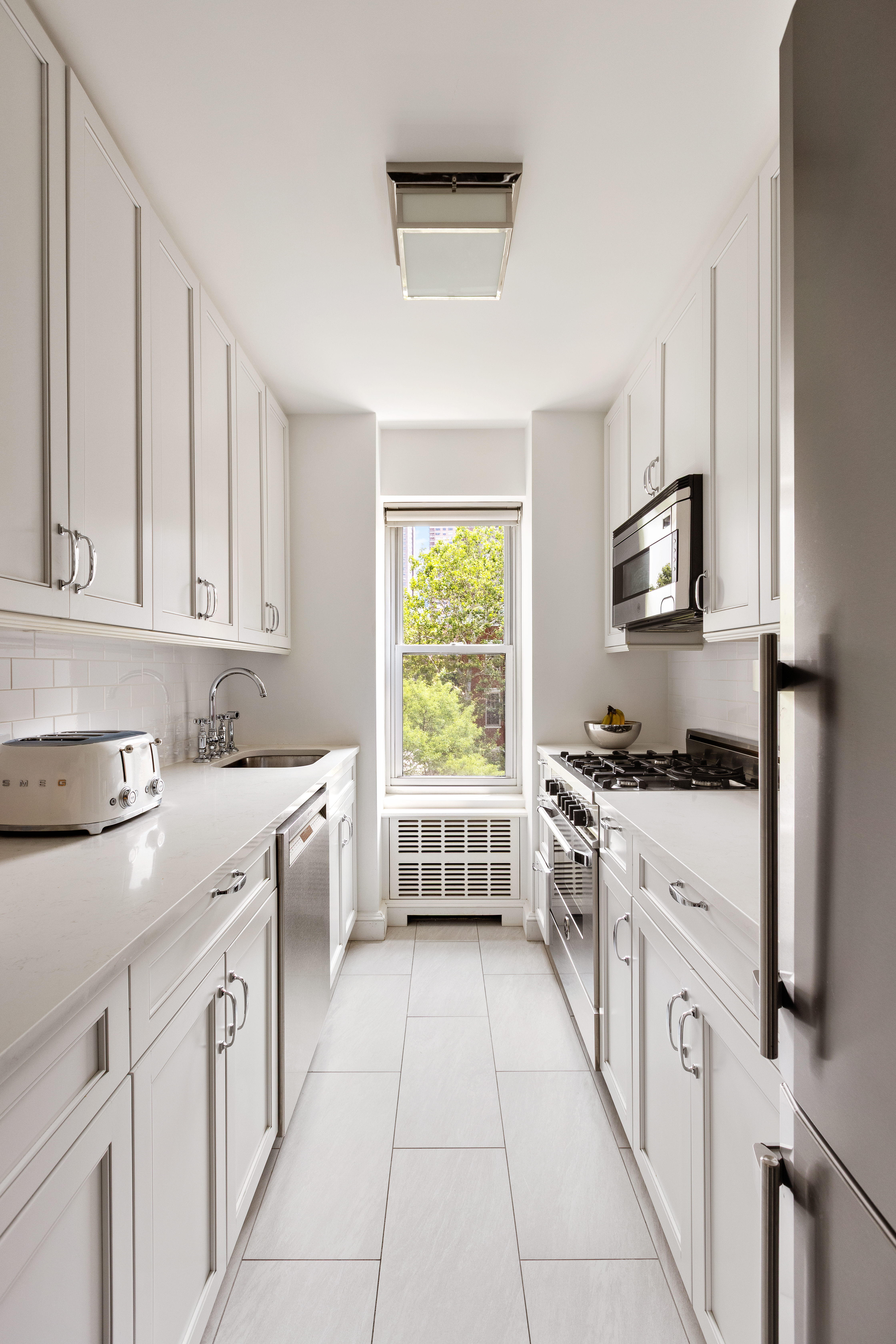 2 5th Avenue, Unit 5F Manhattan, NY 10011 - Photo 3 of 9 a kitchen with a stove top oven sink and cabinets