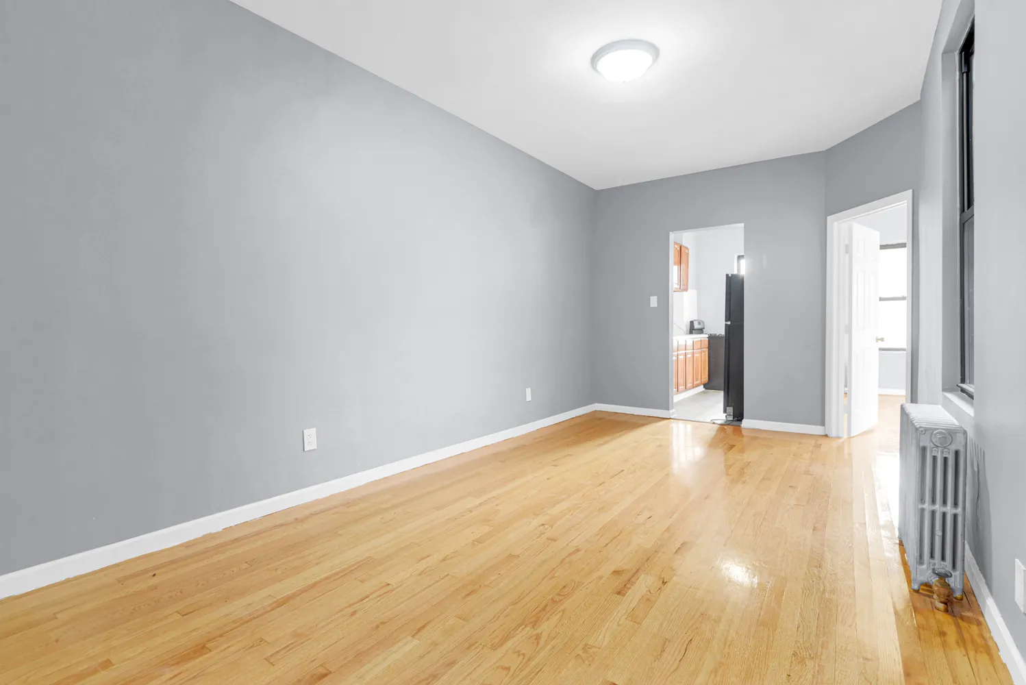a view of empty room with wooden floor
