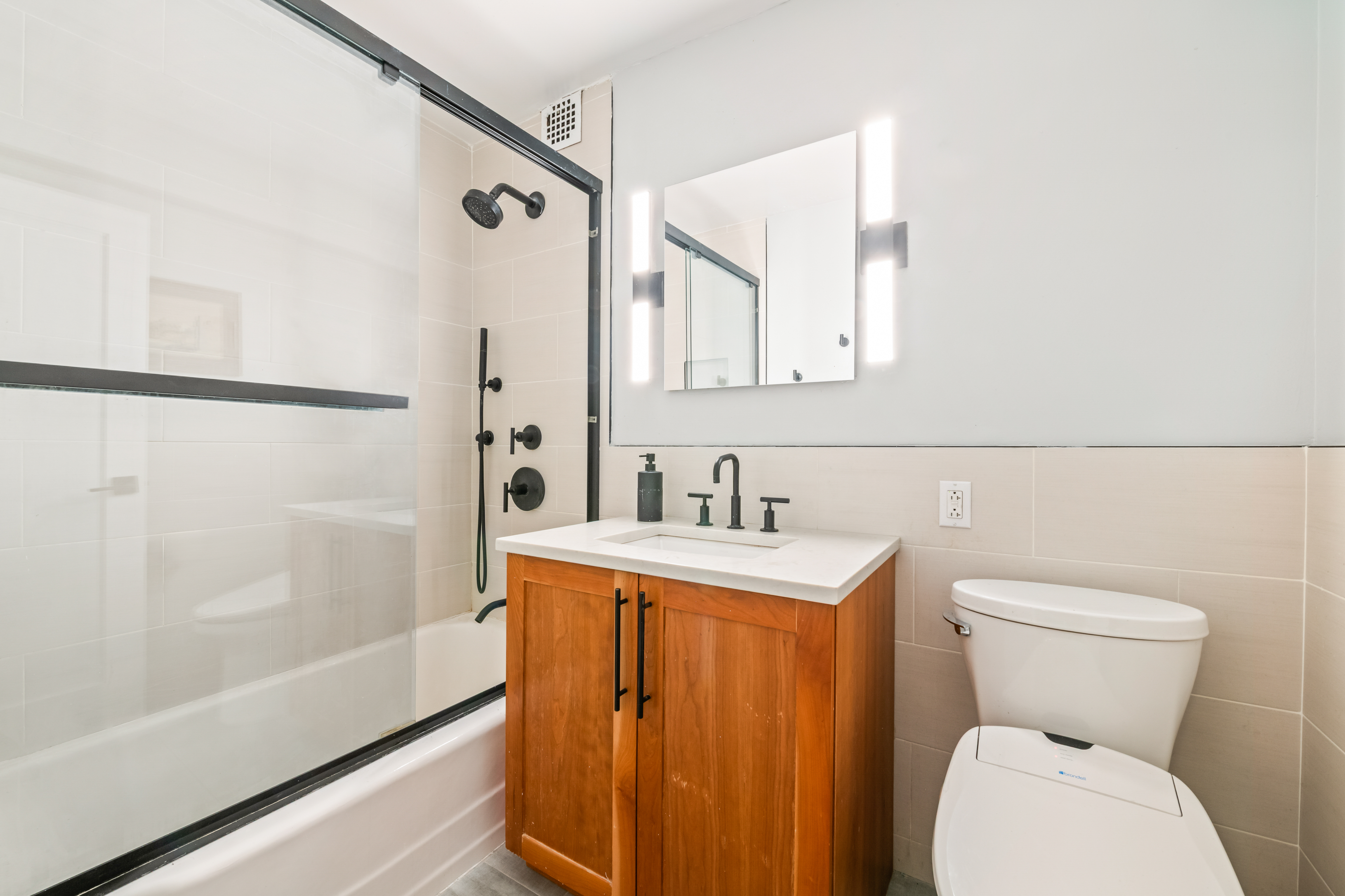 165 Christopher Street, Unit 5AA Manhattan, NY 10014 - Photo 6 of 9 a bathroom with a sink a toilet and shower