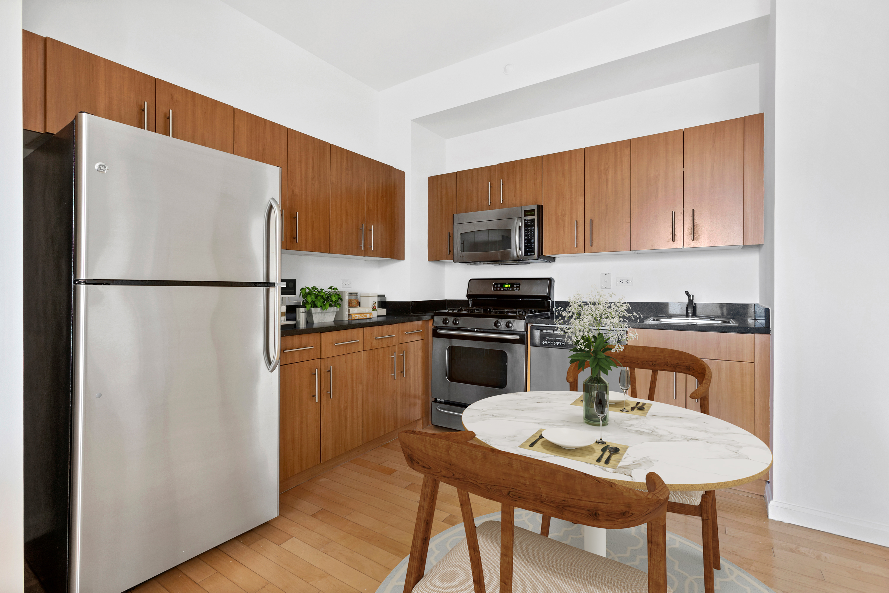 20 West Street, Unit 9A Manhattan, NY 10004 - Photo 4 of 14 a kitchen with a refrigerator a stove a sink and a refrigerator with wooden floor