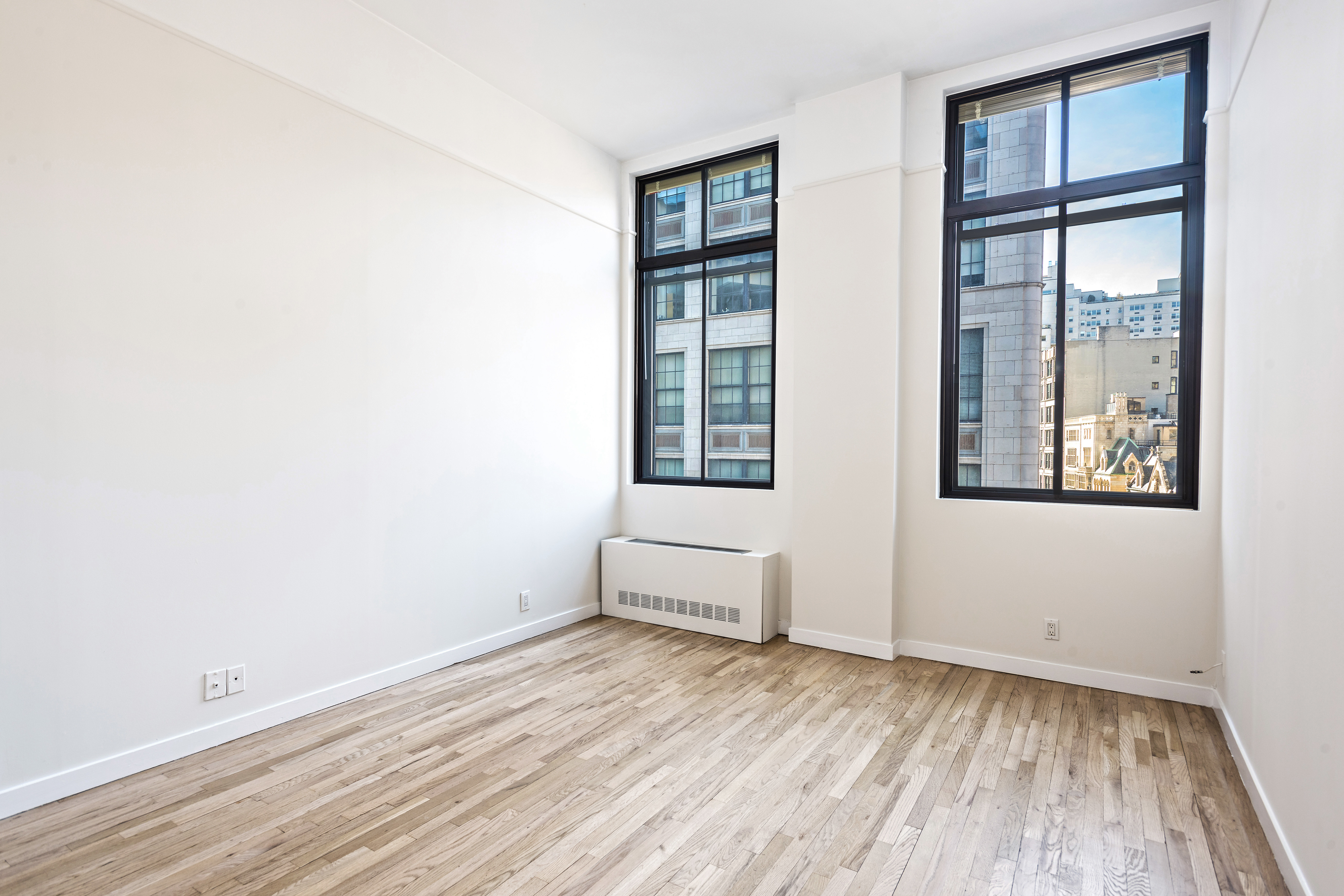 115 4th Avenue, Unit 5C Manhattan, NY 10003 - Photo 8 of 11 an empty room with wooden floor and windows
