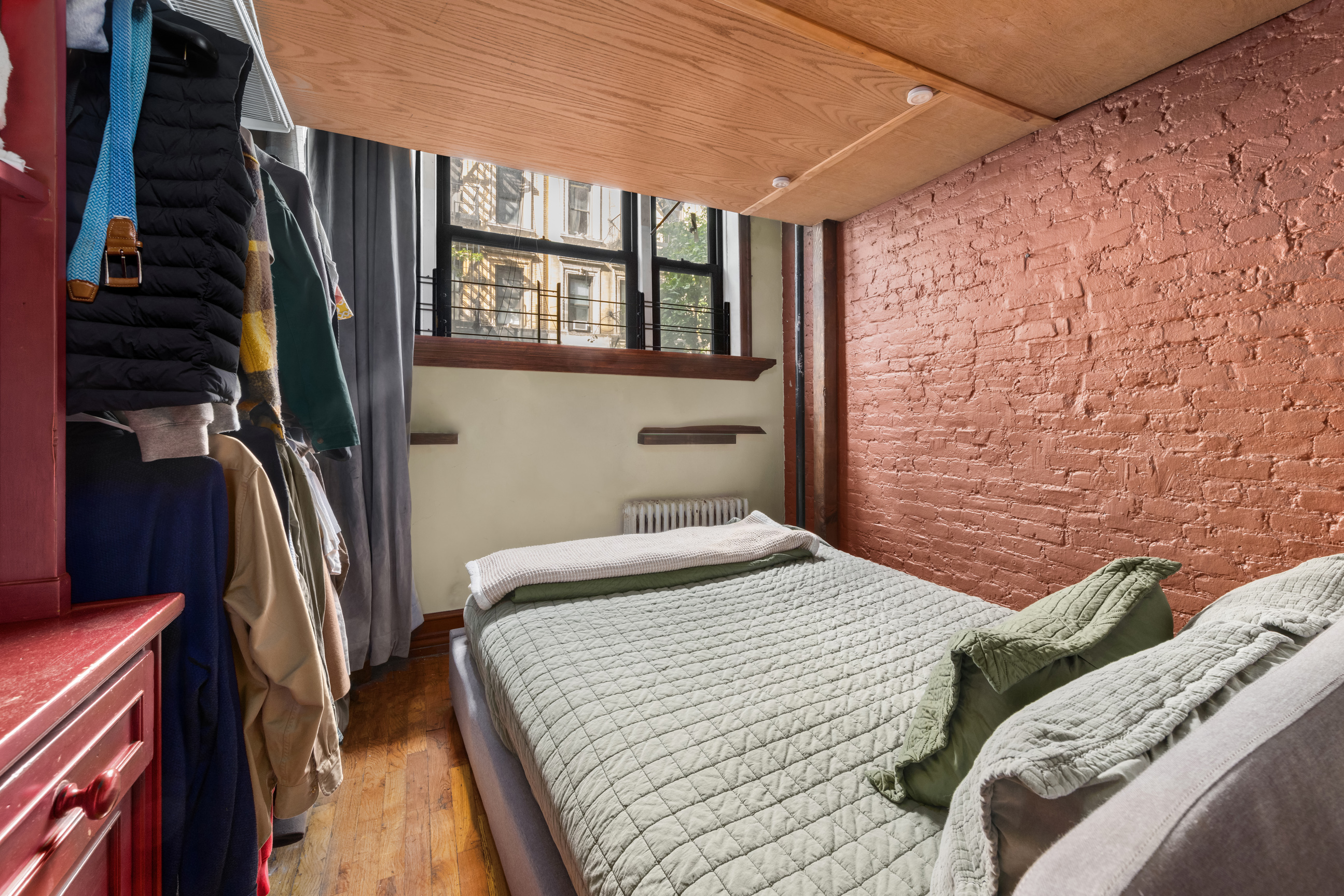 141 Sullivan Street, Unit G4 Manhattan, NY 10012 - Photo 2 of 6 a bedroom with a bed and a walk in closet