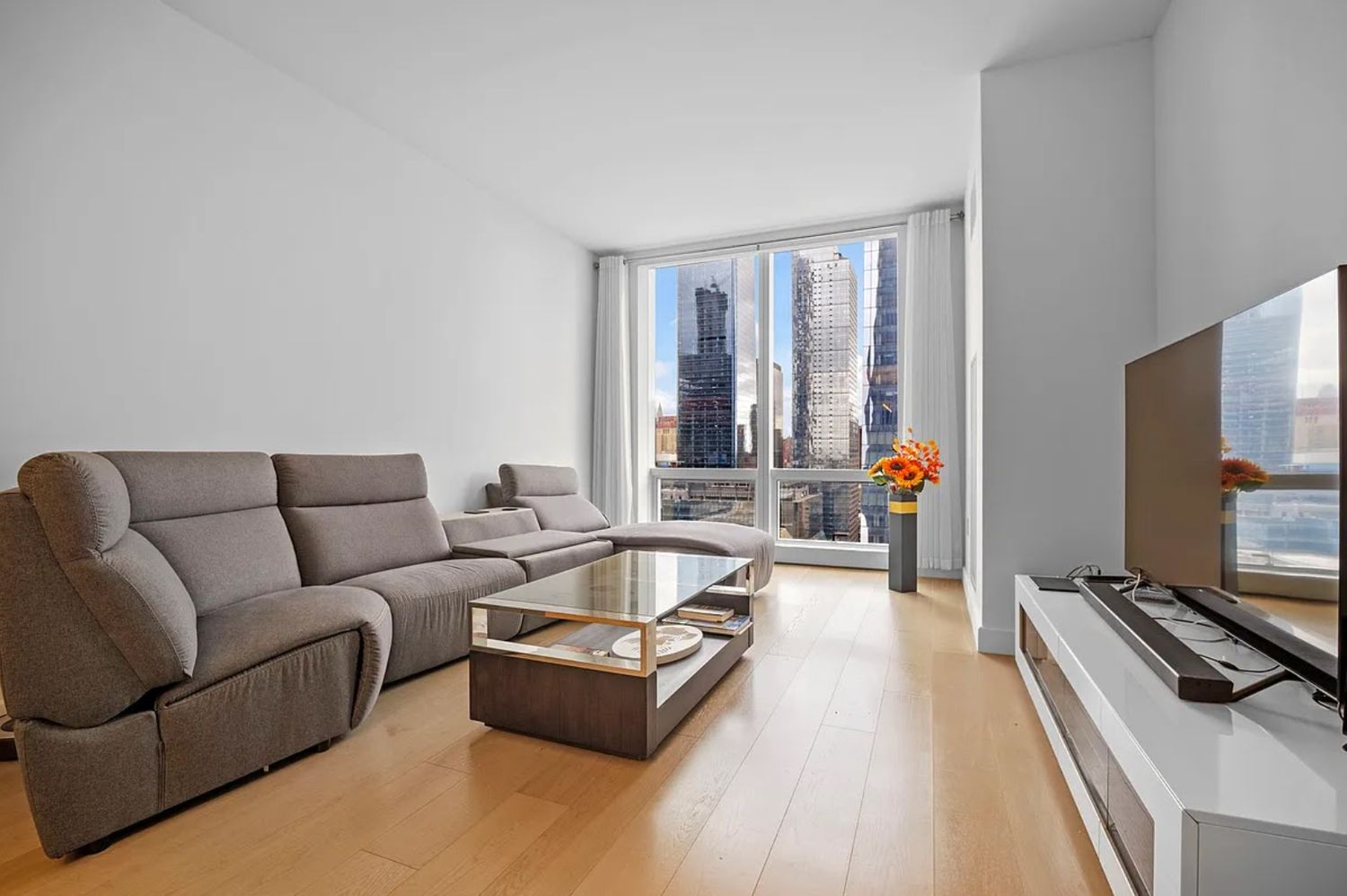 15 Hudson Yards, Unit 28J Manhattan, NY 10001 - Photo 1 of 5 a living room with furniture and a flat screen tv