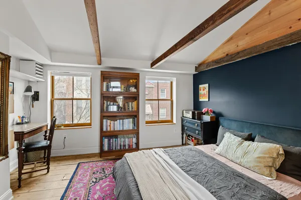 a bedroom with a bed dresser and a window