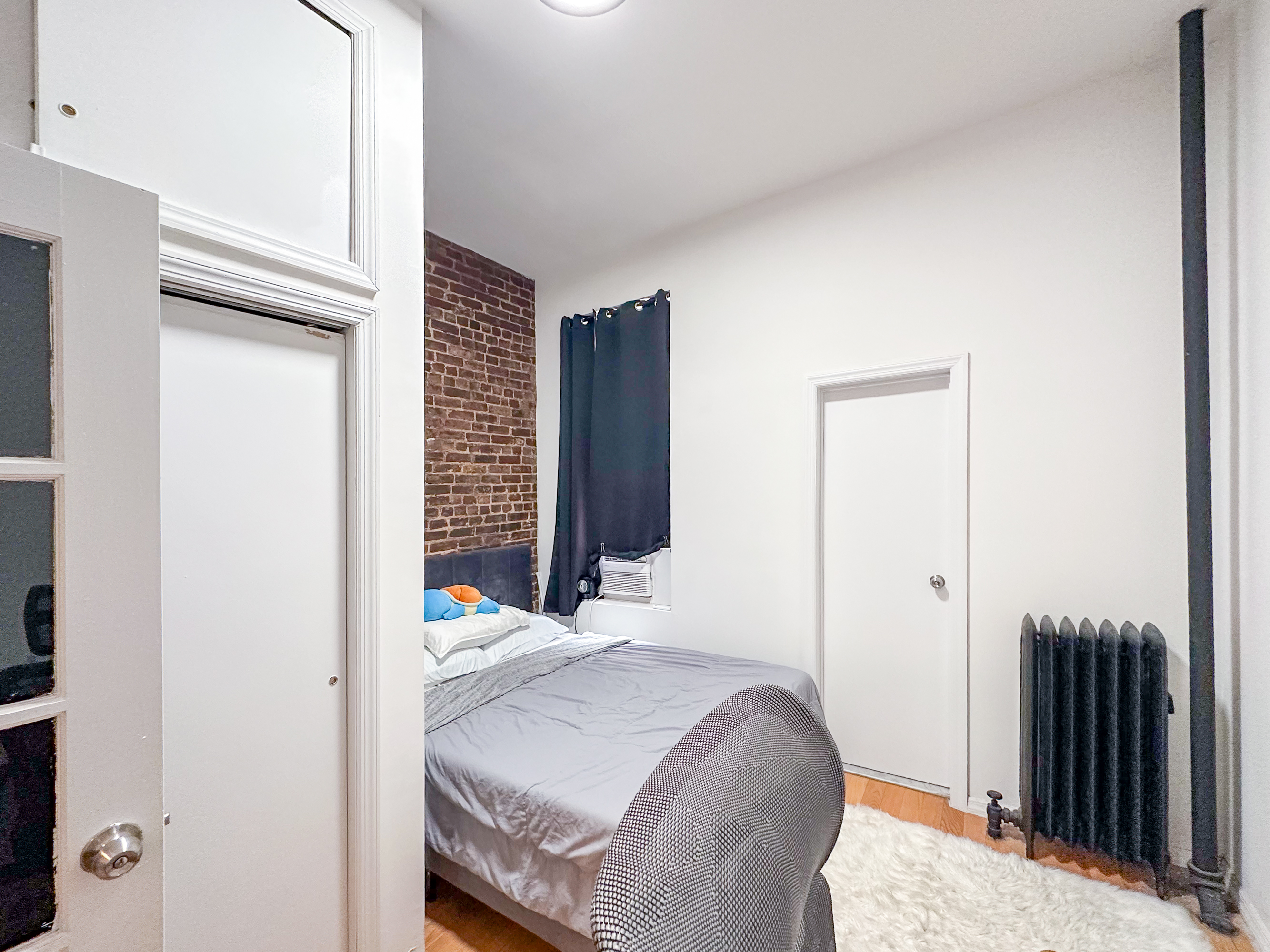 213 East 5th Street, Unit 1 Manhattan, NY 10003 - Photo 11 of 18 a bedroom with a bed and a mirror