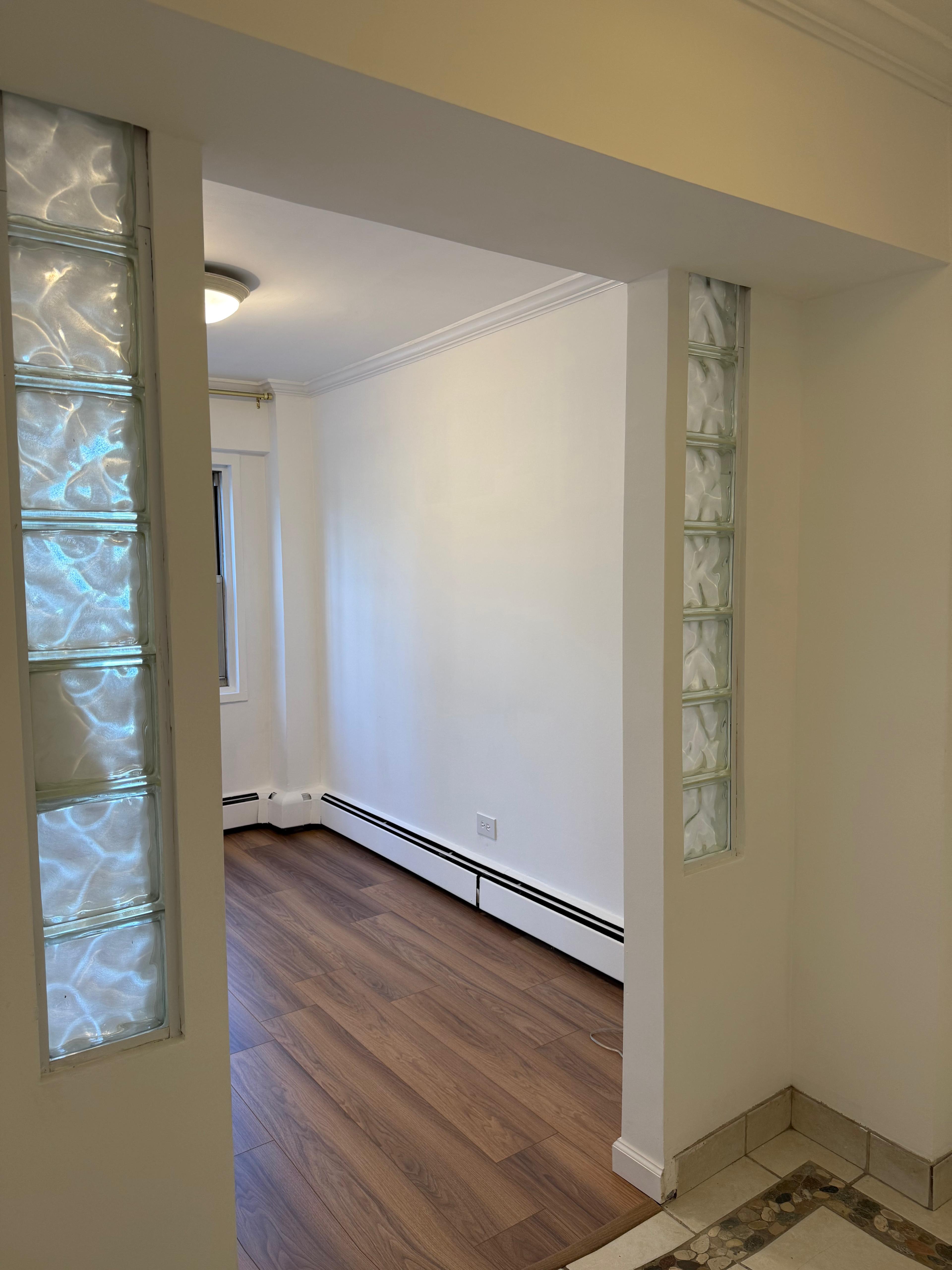 40 Sutton Place, Unit 7A Manhattan, NY 10022 - Photo 7 of 11 an empty room with wooden floor and windows