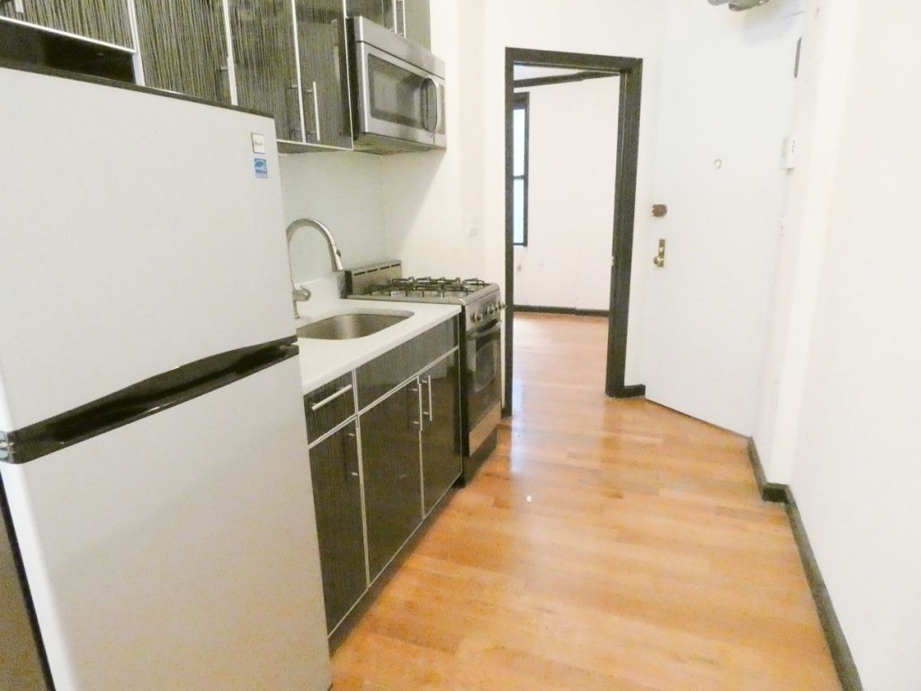 1773 1st Avenue, Unit 9 Manhattan, NY 10128 - Photo 2 of 5 a kitchen with a sink stove and microwave