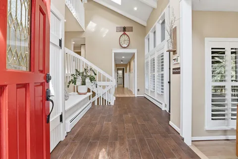 a view of a hallway with wooden floor and staircase