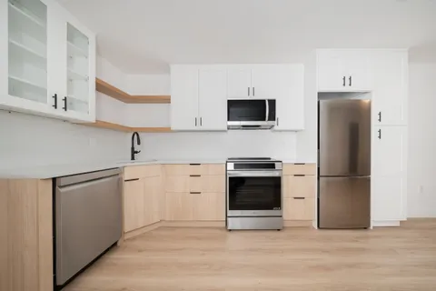 a kitchen with stainless steel appliances a refrigerator stove and microwave