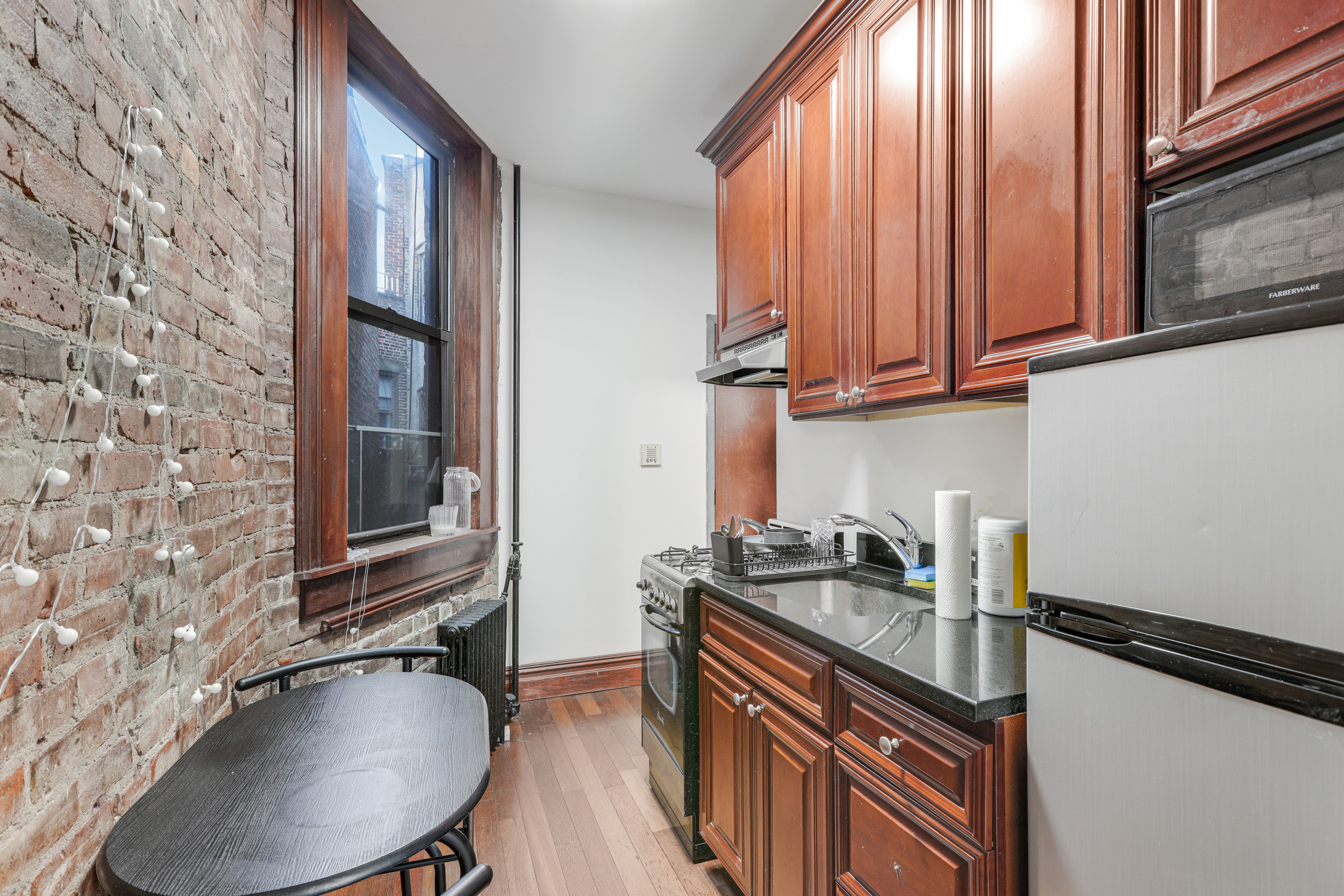 336 East 5th Street, Unit 6FE Manhattan, NY 10003 - Photo 2 of 4 a kitchen with a sink a stove and cabinets