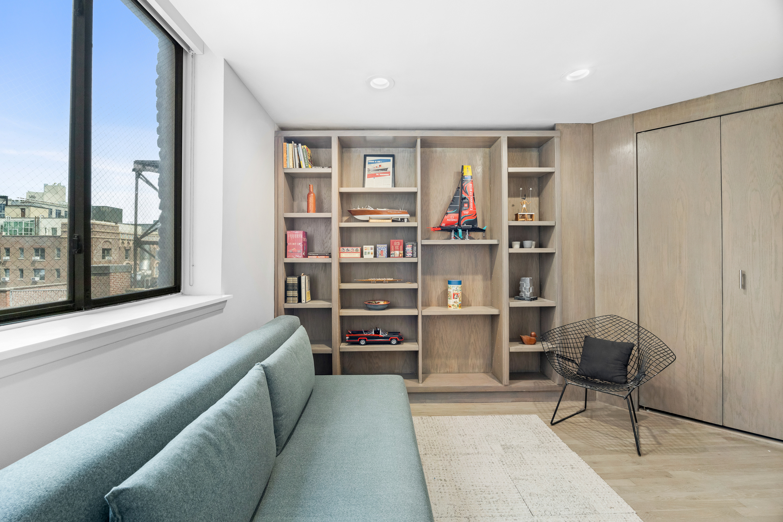330 West End Avenue, Unit PHB Manhattan, NY 10023 - Photo 13 of 20 a living room with a couch and a bookshelf with wooden floor