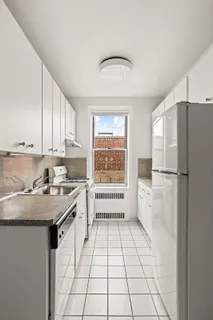 a kitchen with a refrigerator a stove a sink and cabinets