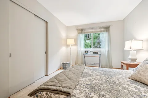 a bedroom with a bed and a large window