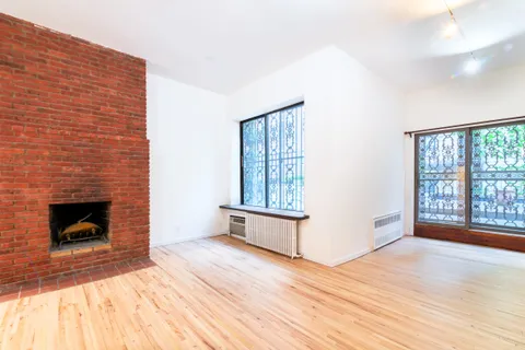 a view of empty room with wooden floor and fireplace