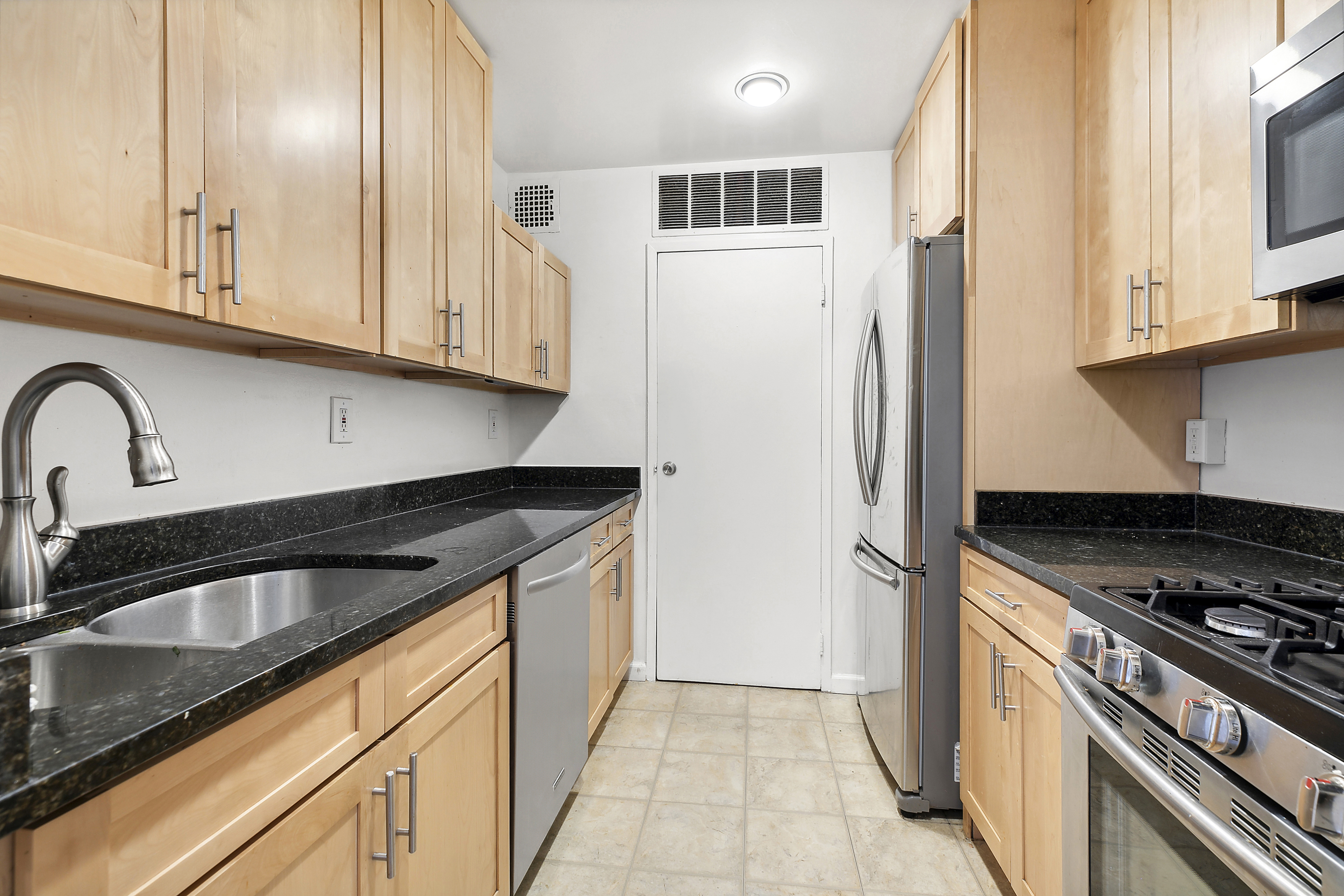 253 West 73rd Street, Unit 8G Manhattan, NY 10023 - Photo 3 of 5 a kitchen with granite countertop a sink stove and refrigerator