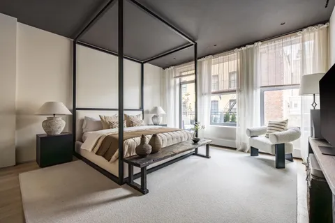 a spacious bedroom with a bed and a large window