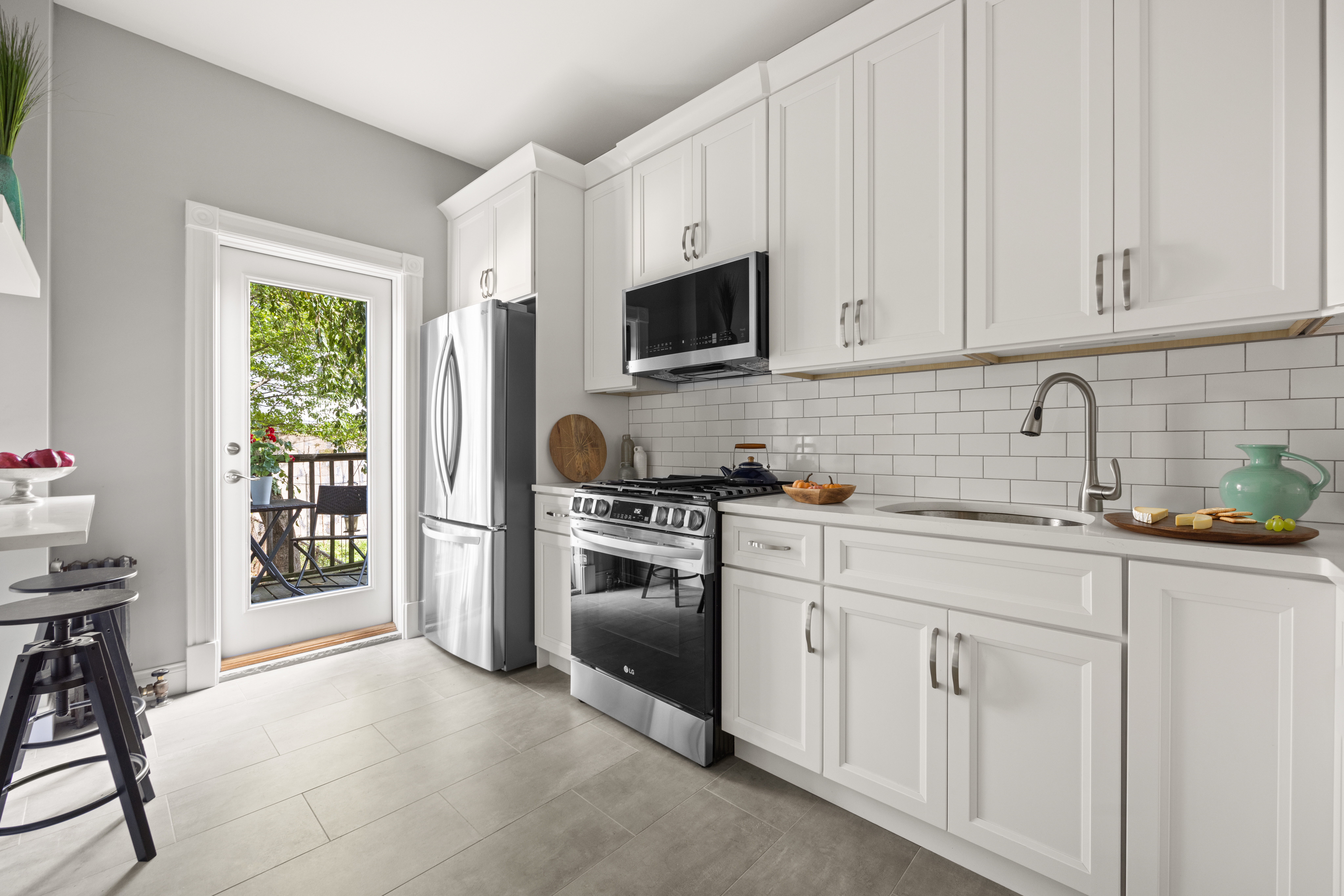 99 East 2nd Street Brooklyn, NY 11218 - Photo 8 of 24 a kitchen with white cabinets and stainless steel appliances